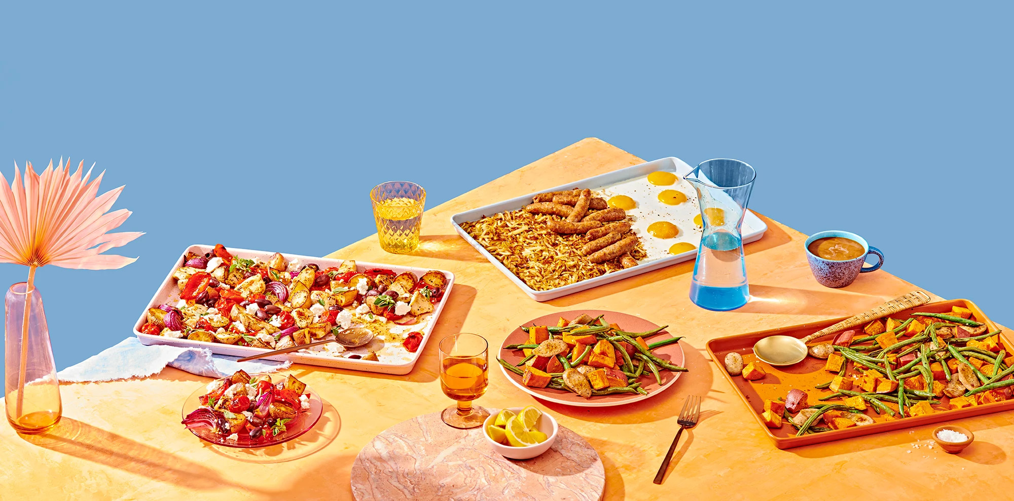 Group shot of three sheet pan recipes on a wood table with blue background