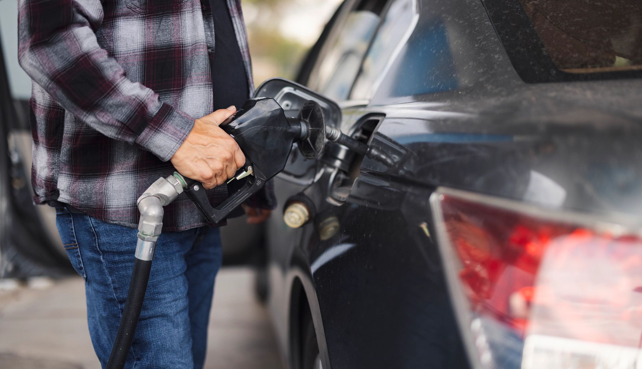Smart Guide to Car Rentals a closeup of a person pumping gas into a car