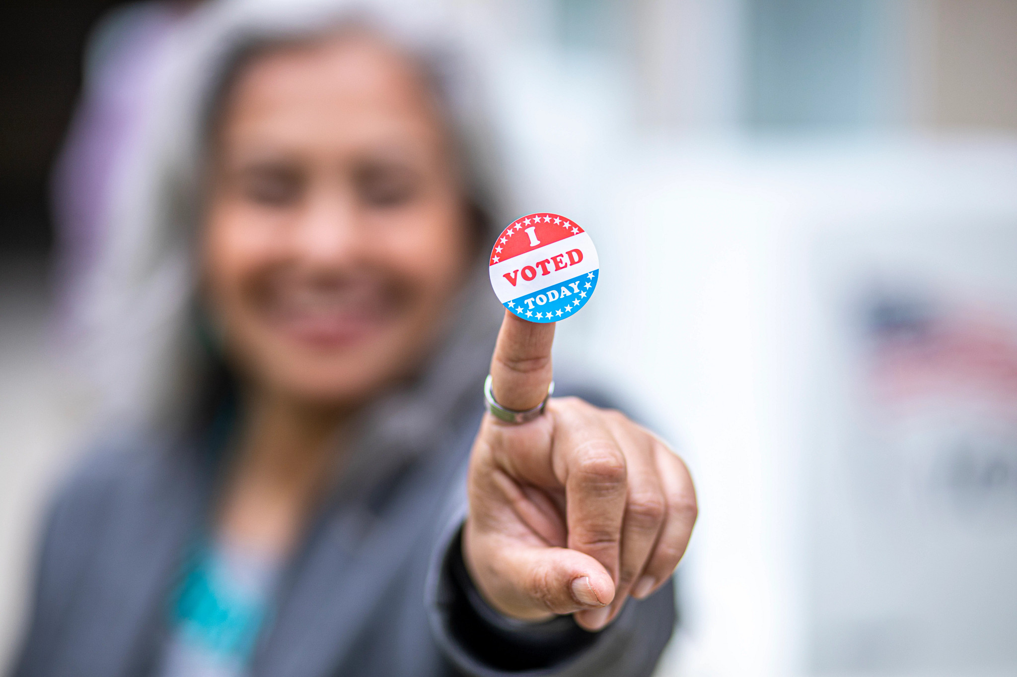 woman showing an "i voted" sticker