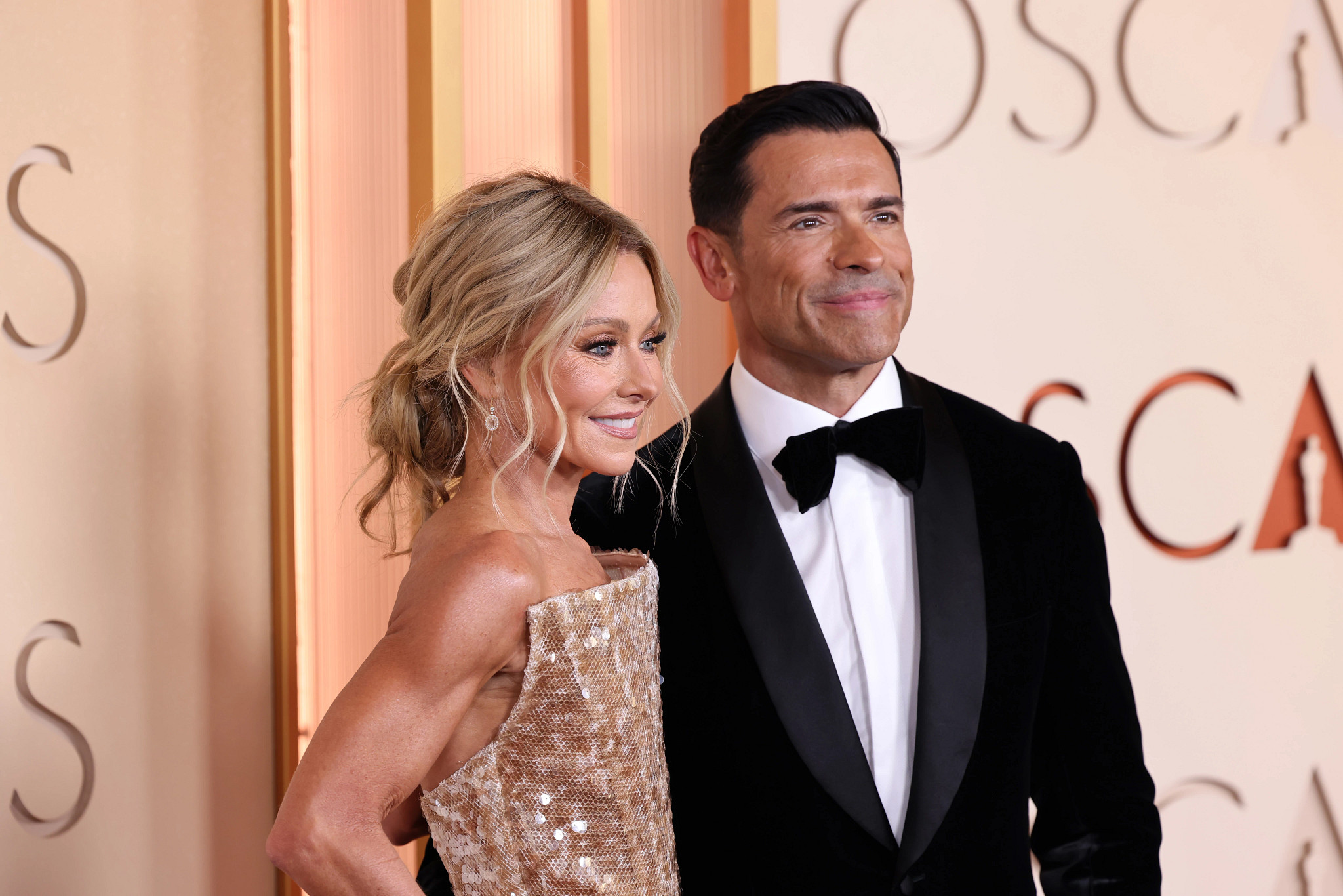 kelly ripa and mark consuelos posing together at a red carpet event