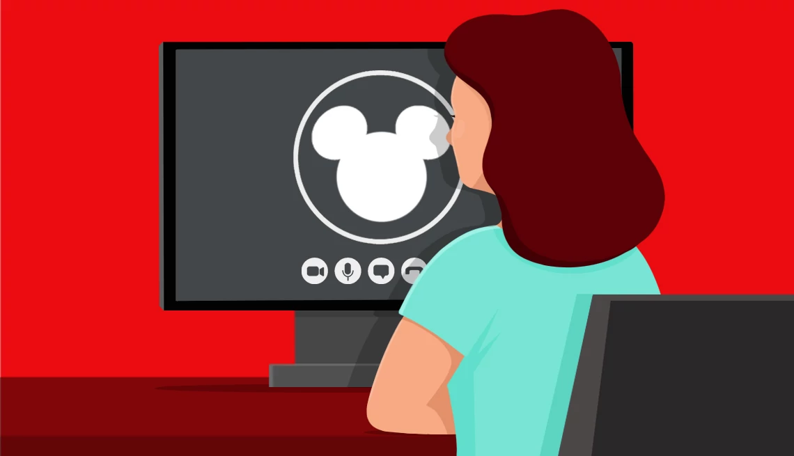 woman sitting behind a computer screen with disney logo on it