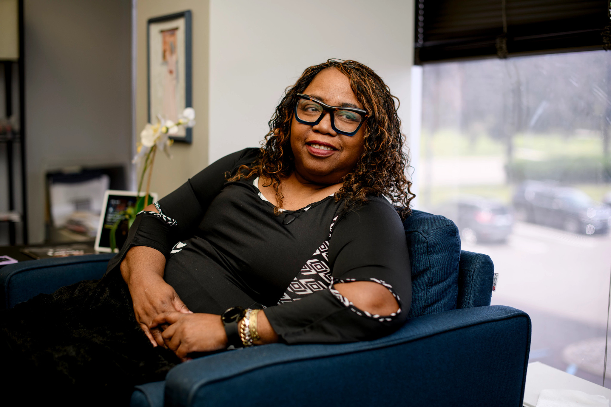 a woman sits and smiles in an office chair