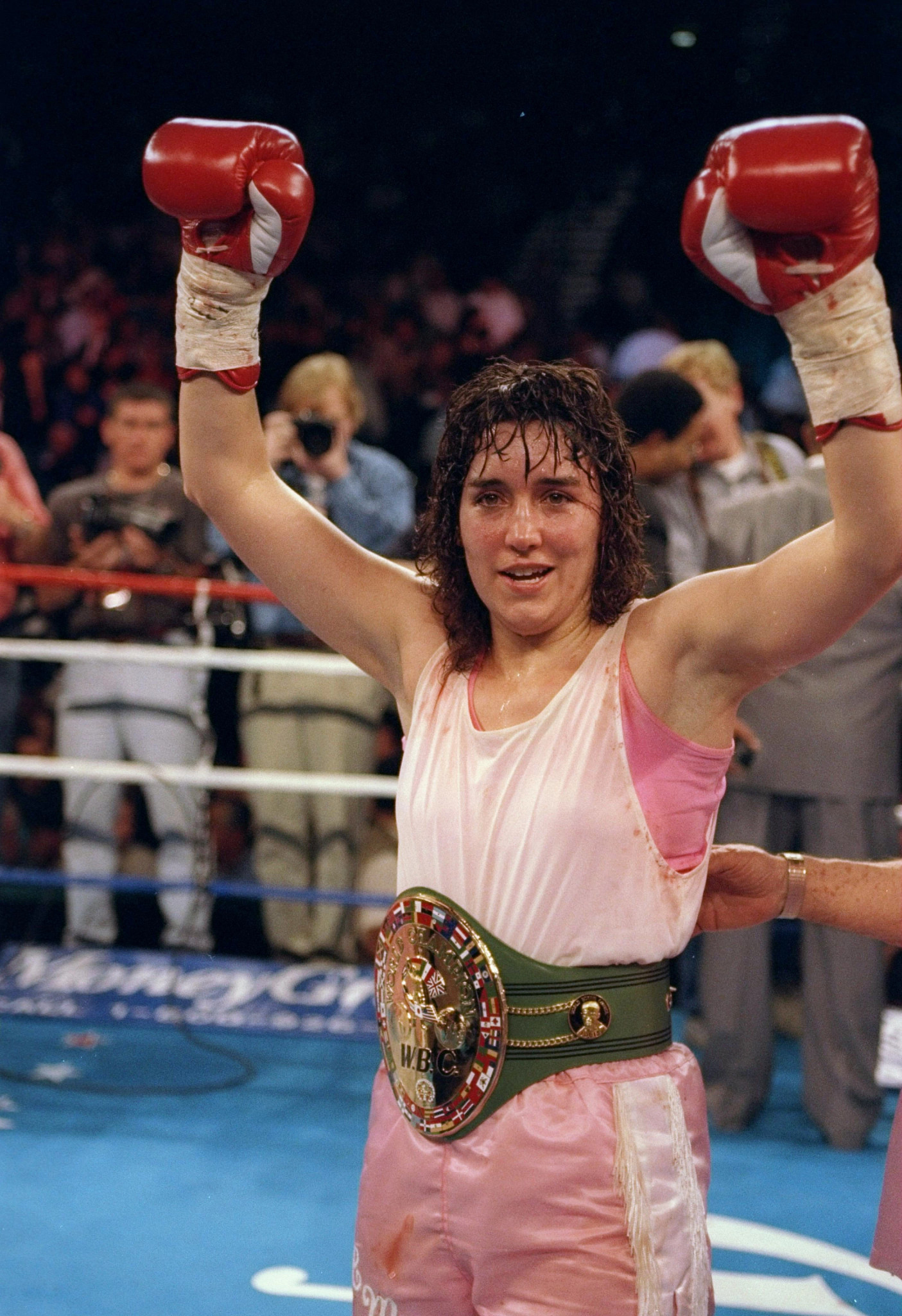christy martin raising her gloves during a boxing match