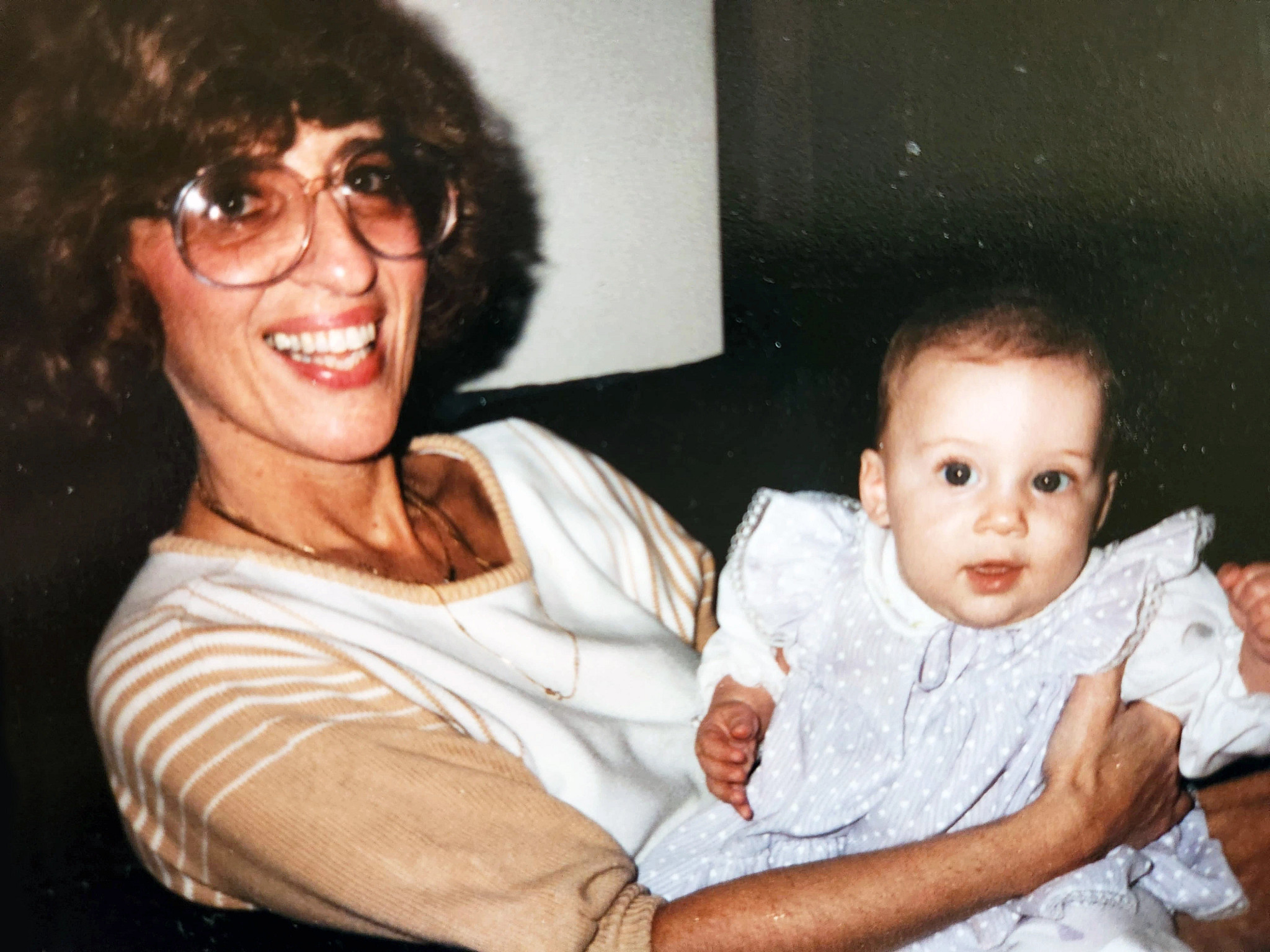 a photo shows Rachel Azaroff as a baby being held by her grandmother in 1984