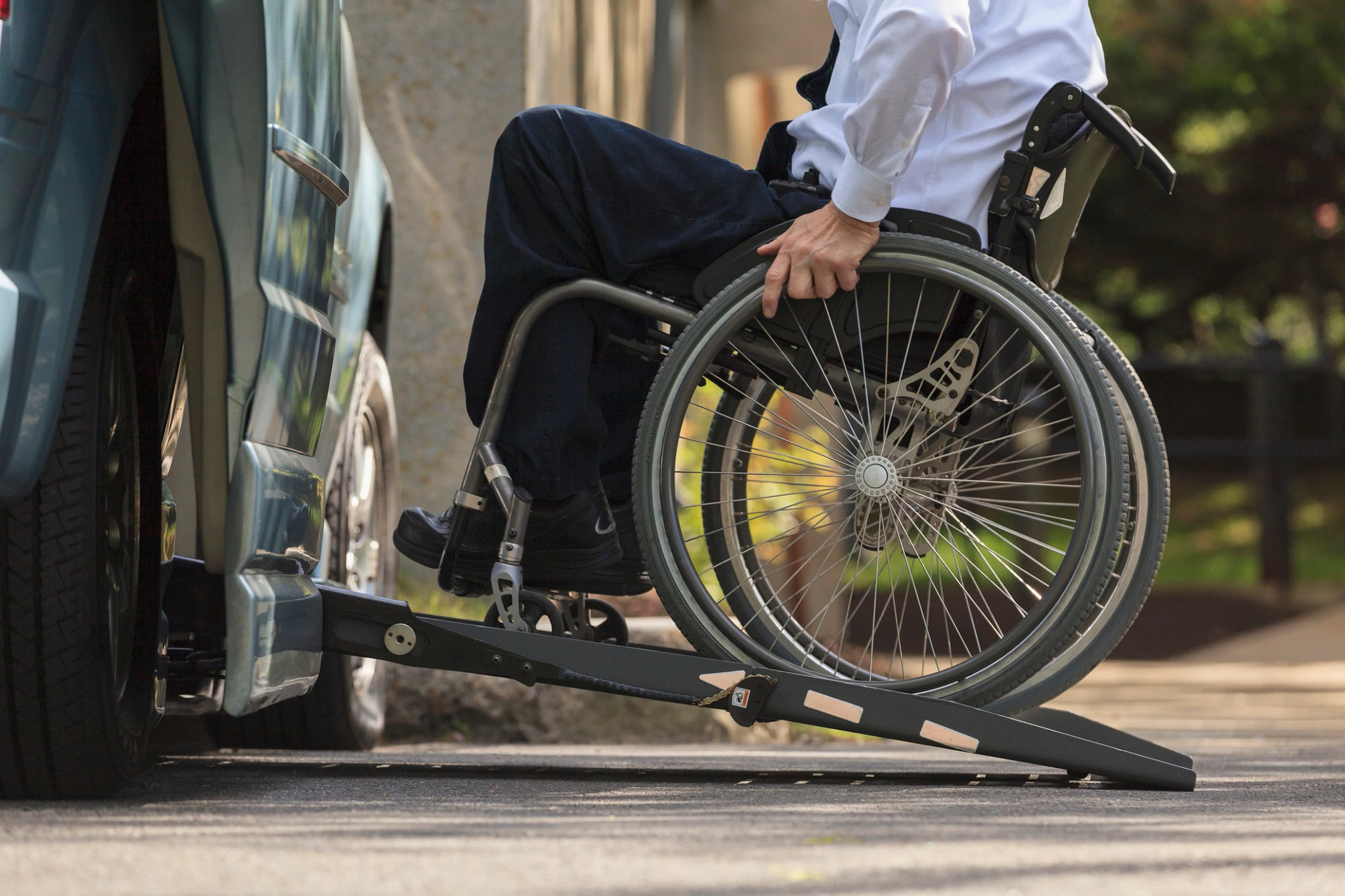 a person in a wheelchair uses a ramp to get into a vehicle
