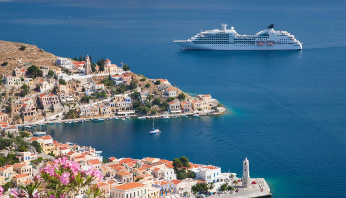 Cruise ship sailing off the coast of Mediterranean village