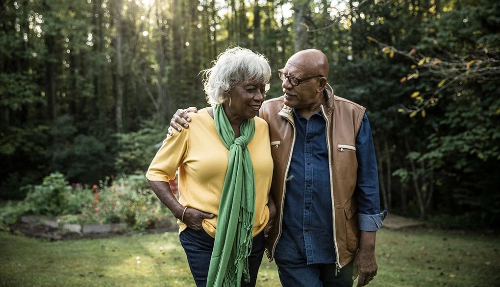 Talking with your partner may help with your sleeping problems A man and woman walking together in the woods