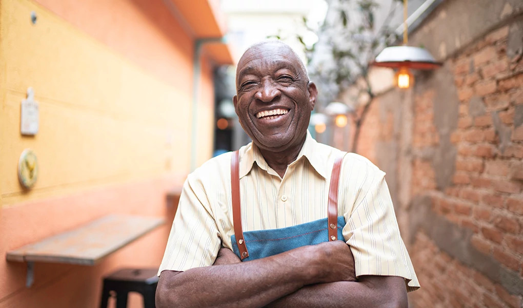 A smiling waiter standing outside