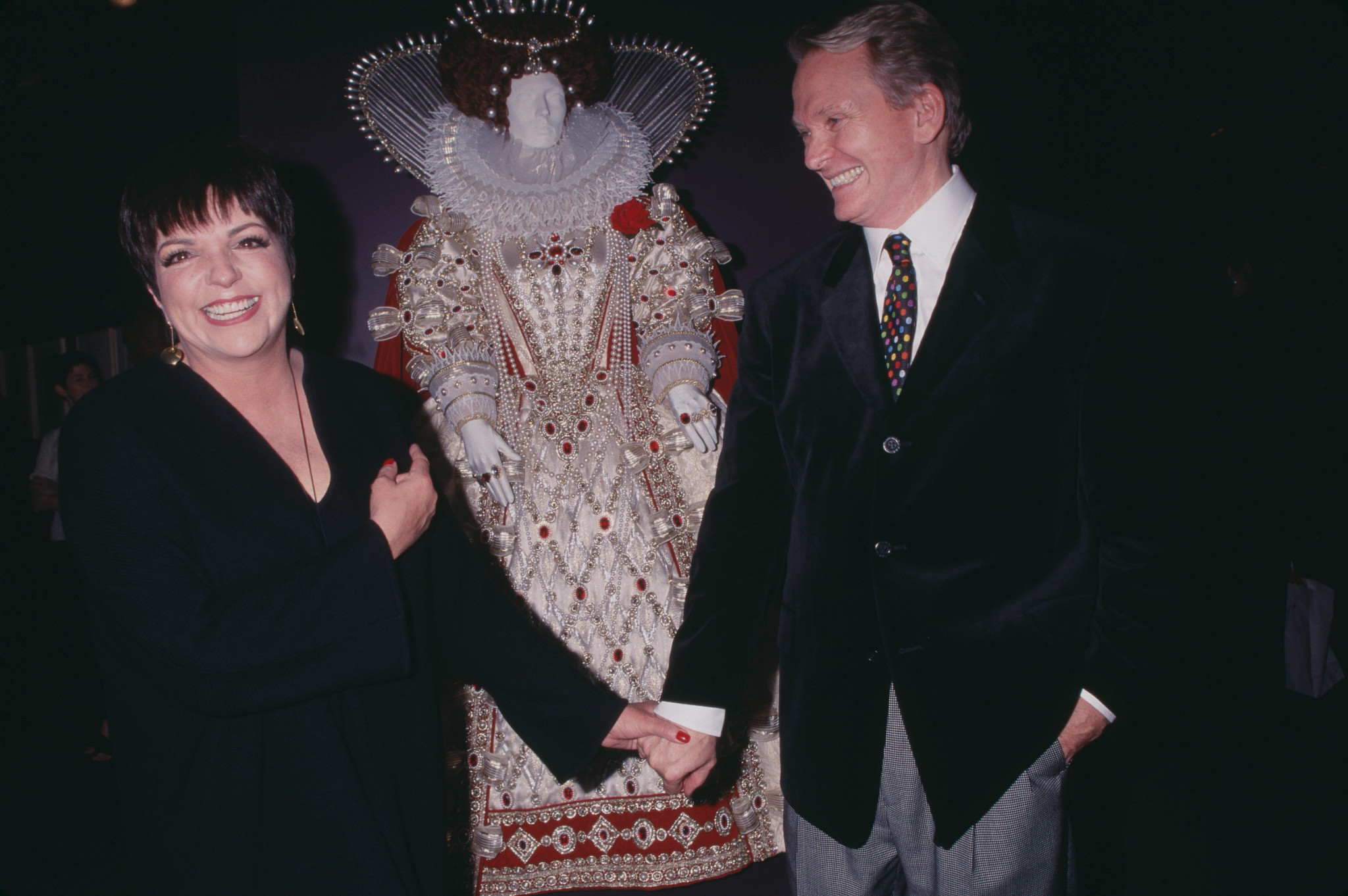 bob mackie and liza minnelli pose with a costume displayed at a museum
