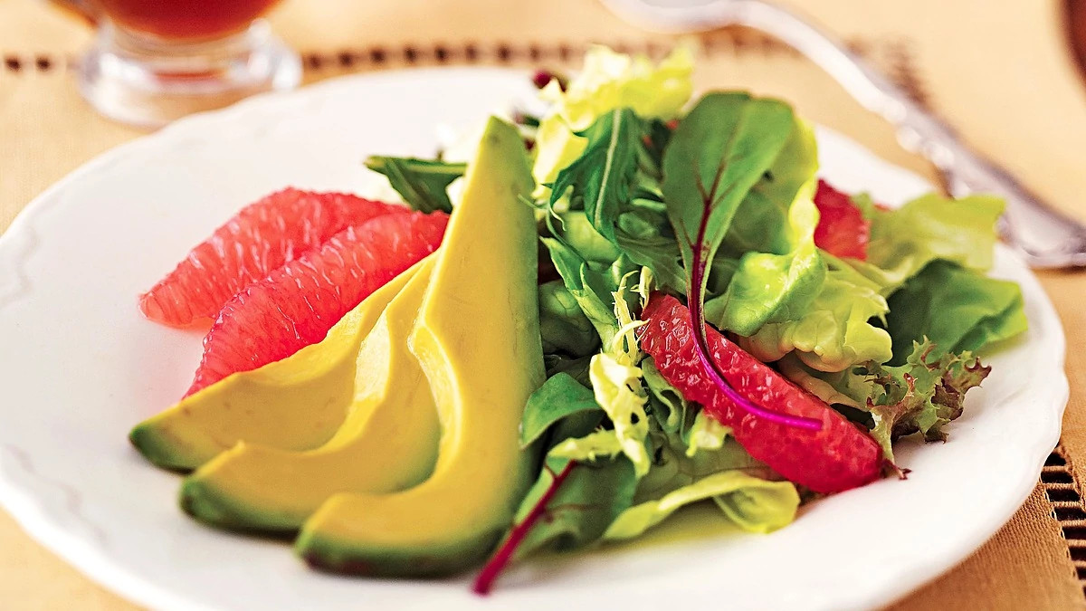 A close-up view of avocado and grapefruit salad on a plate