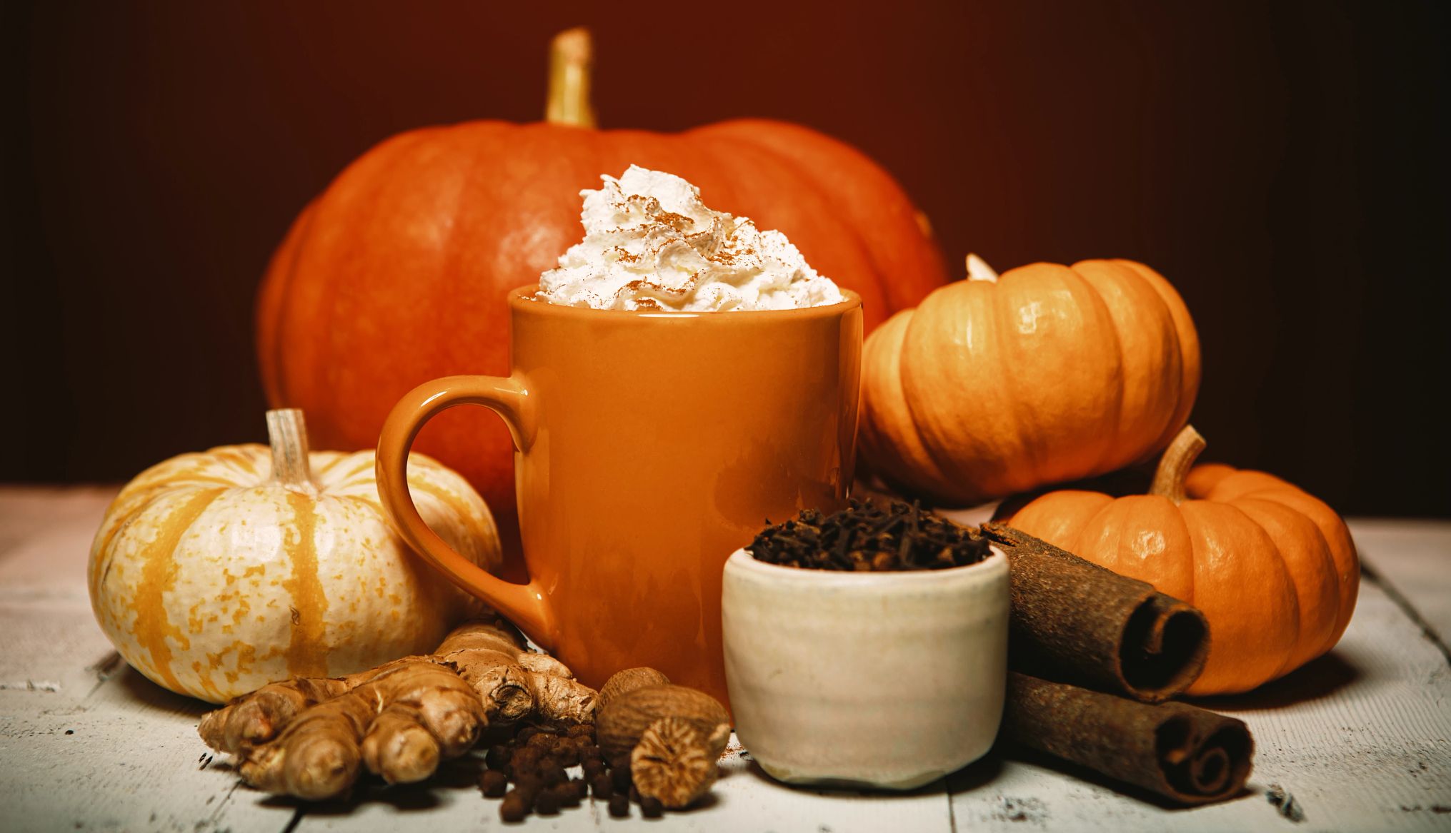 calabazas y una taza de bebida de especias de calabaza