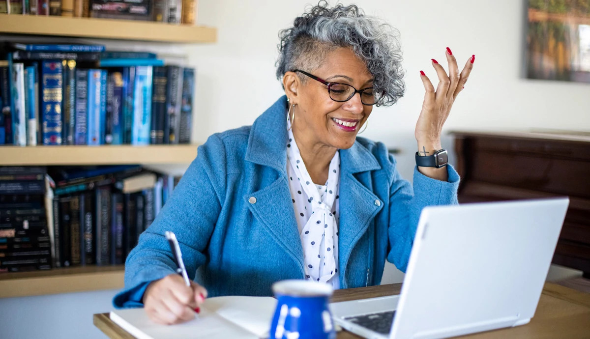 Woman smiling and looking at laptop