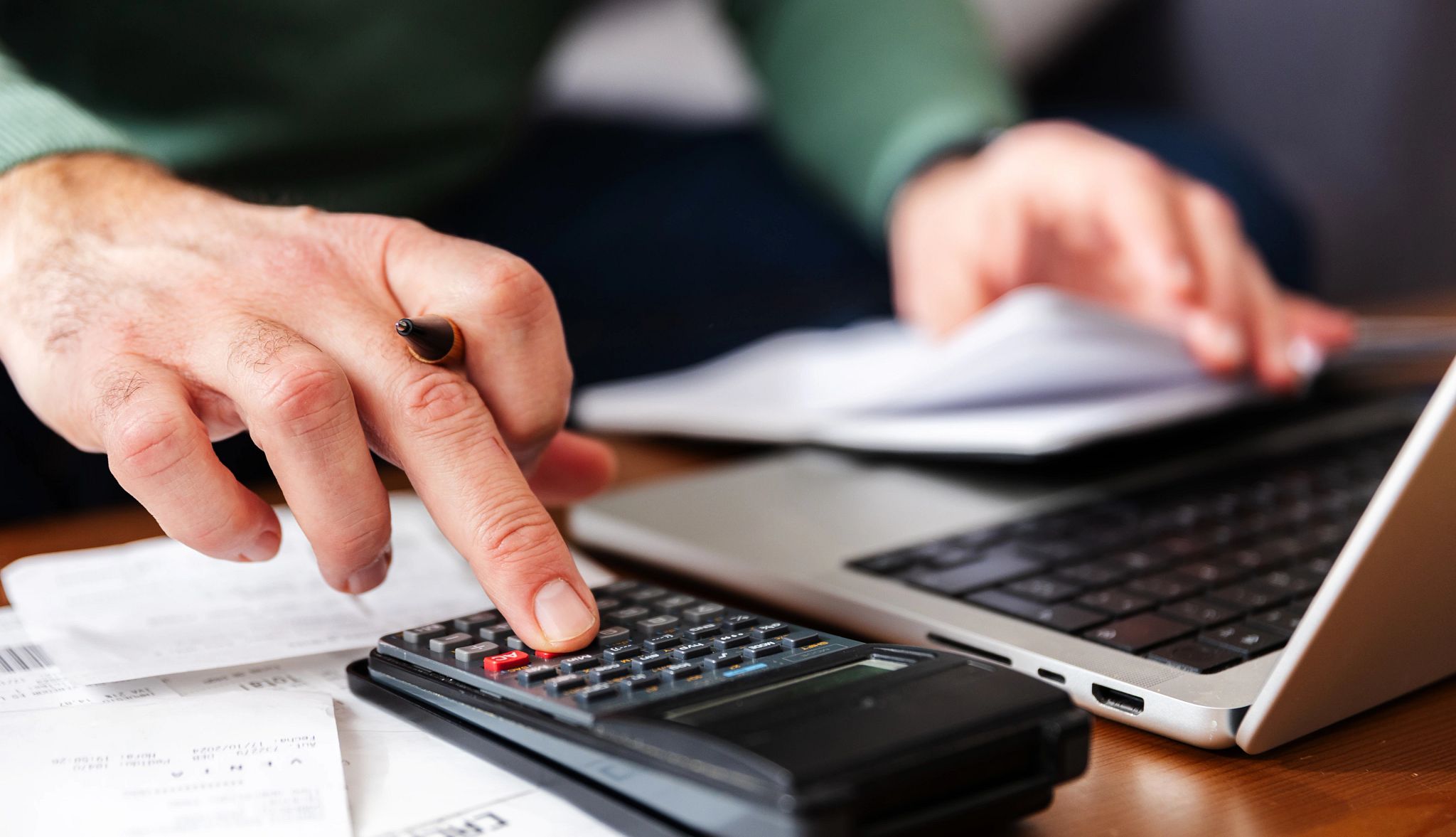 Estimate Retirement Income a hand types on a calculator