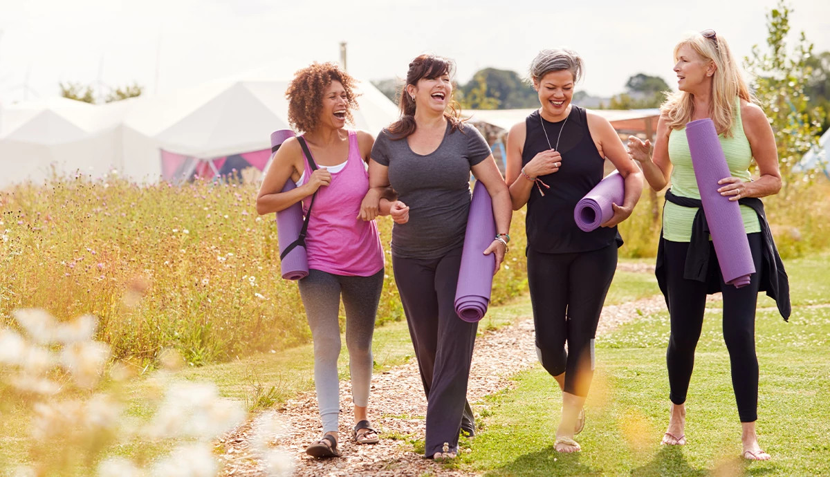 Group of friends walking with yoga mats on a weekend outing