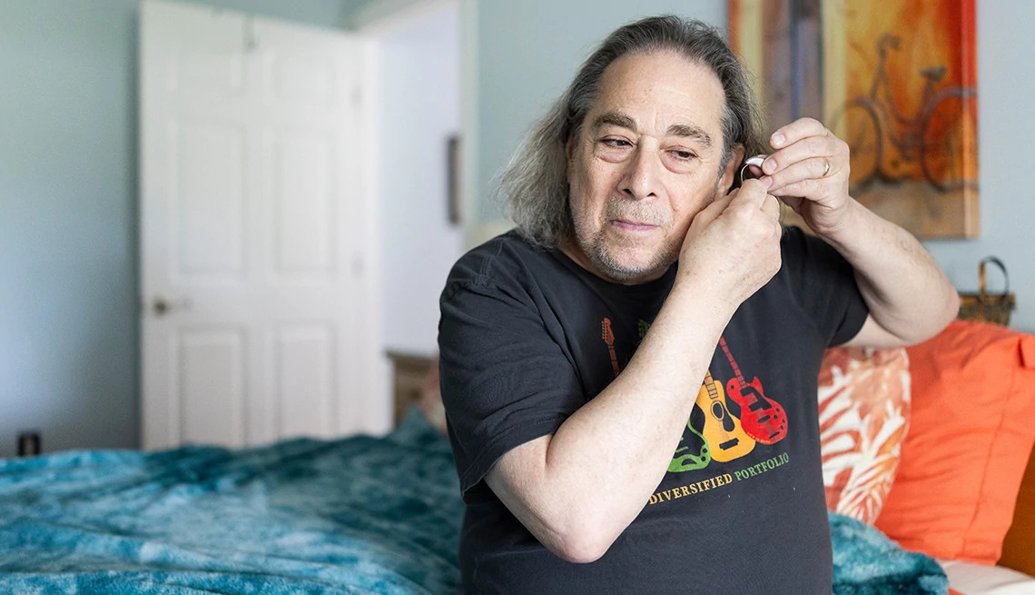 Rosch putting in his hearing aids