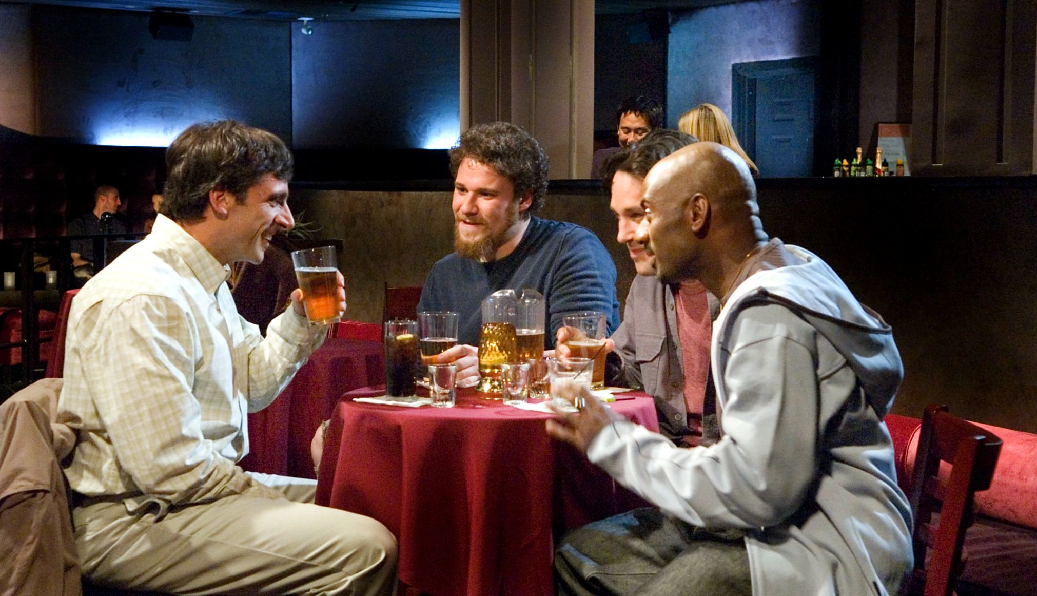 The 40-Year-Old Virgin Steve Carell, Seth Rogen, Paul Rudd and Romany Malco sitting together at a table drinking beer in the film The 40-Year-Old Virgin