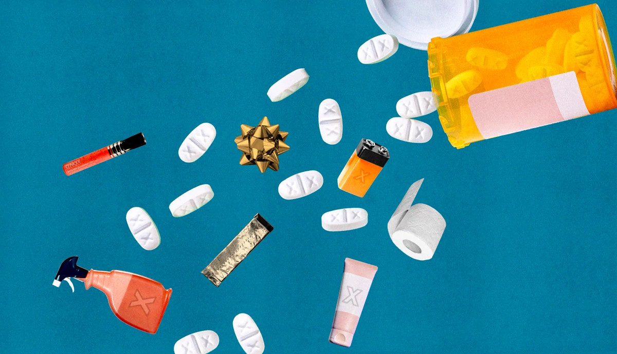 White pills and miscellaneous household items spill out of an orange pill bottle.