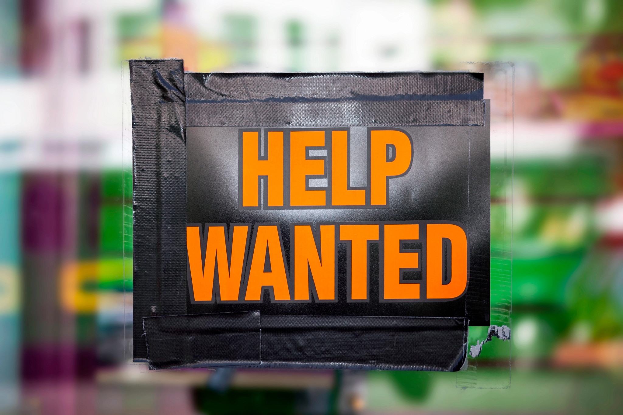 a help wanted sign in a window