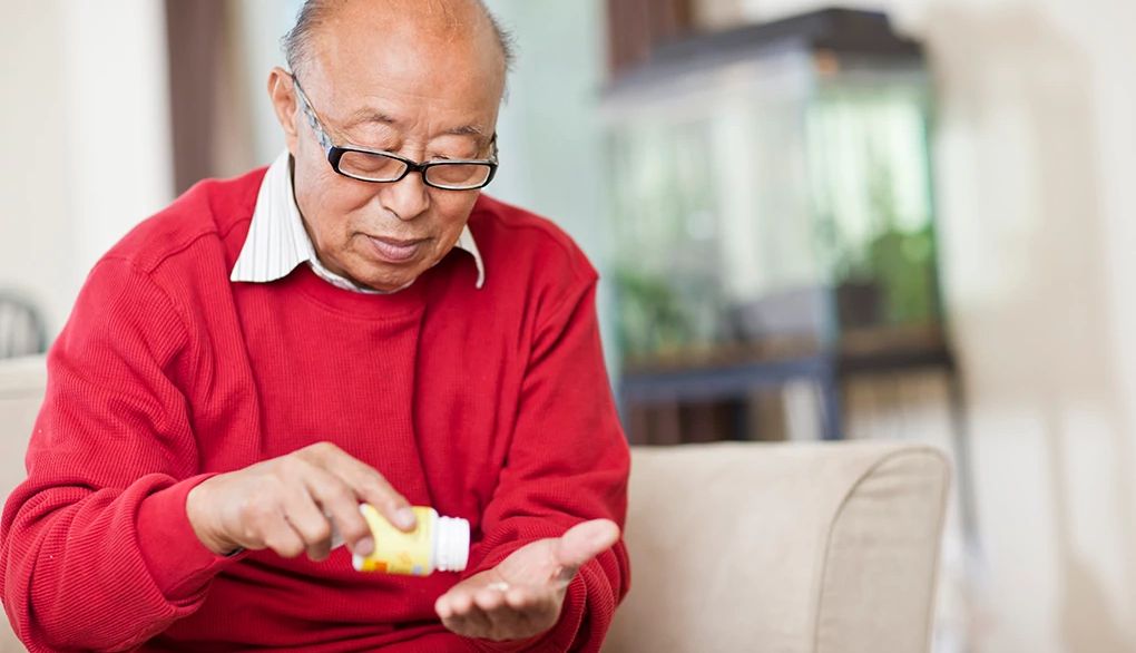 Common cold and sleep meds may be linked to greater dementia risk A man pouring a pill from a bottle into his hand