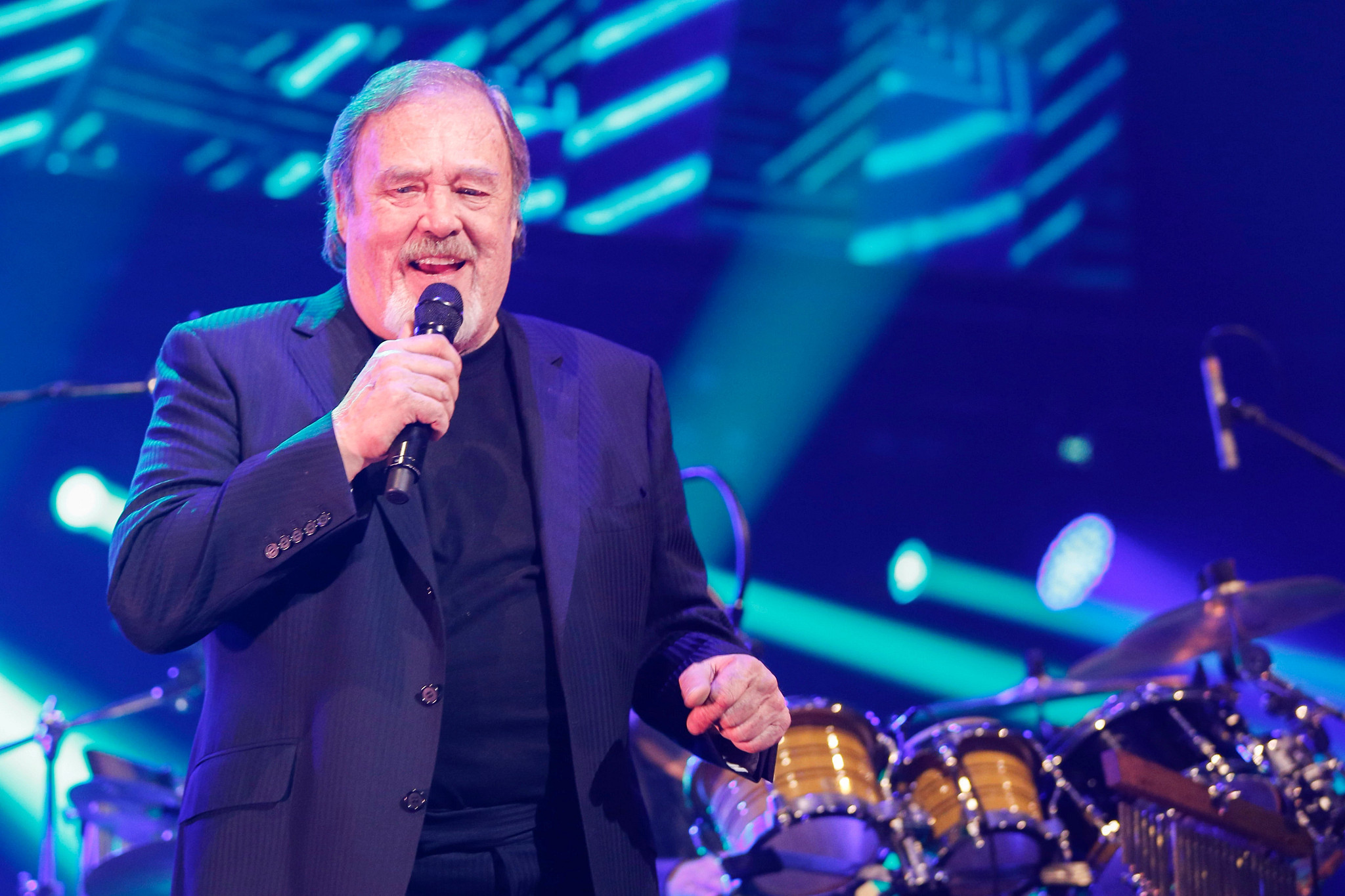 david clayton-thomas in a suit singing into a microphone