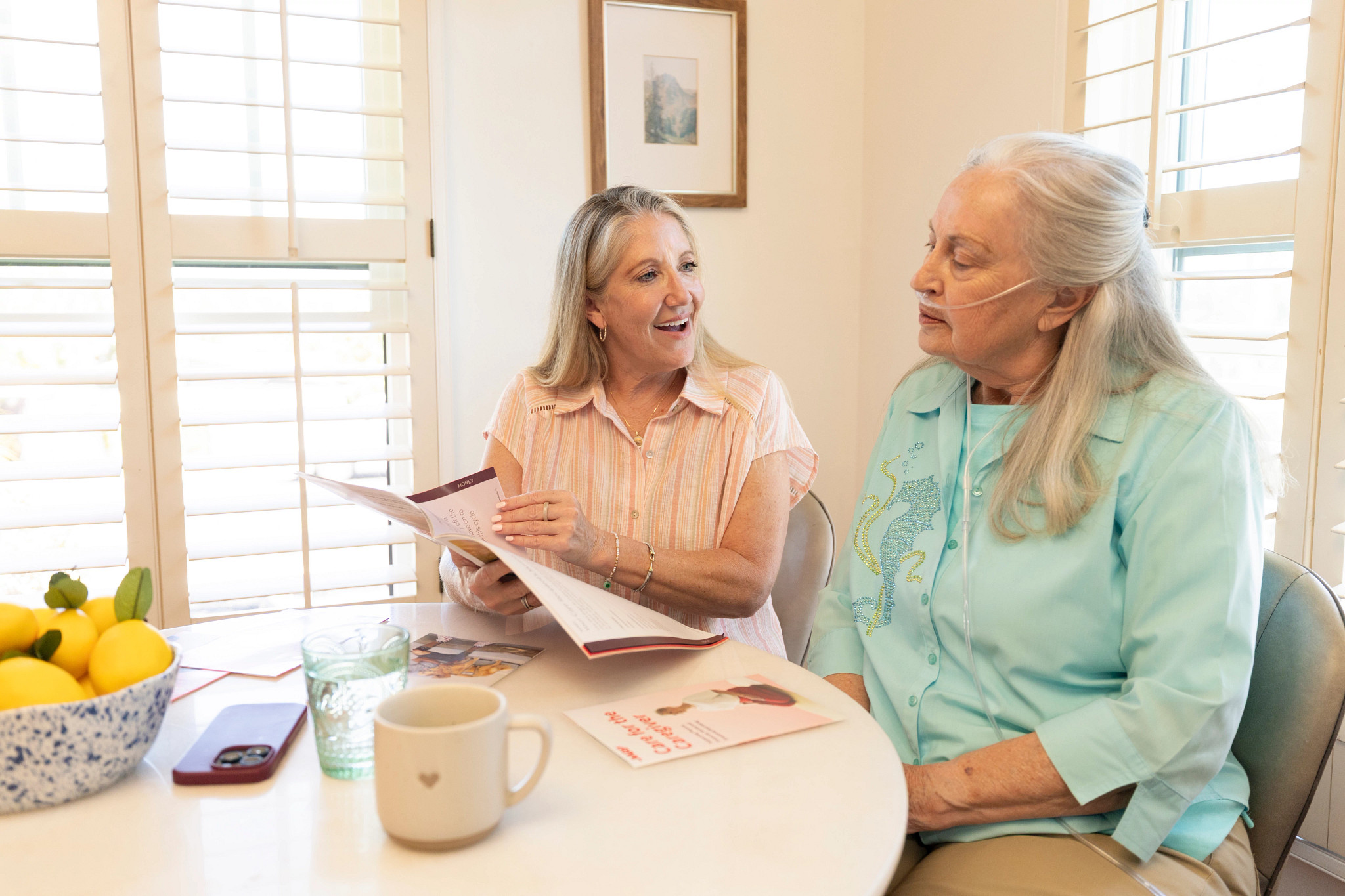 Two women review healthcare materials together at home, highlighting informed decision-making and supportive care planning. 