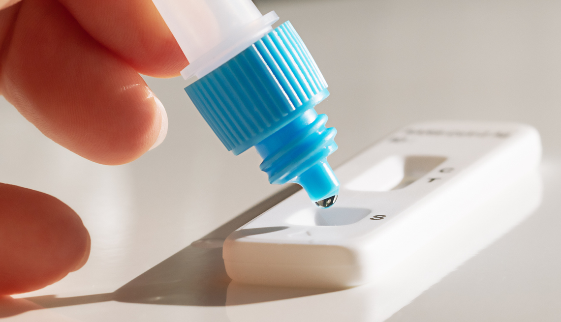 Free COVID Testing Program Suspended conducting a covid and disease test with a set and arm on a white background