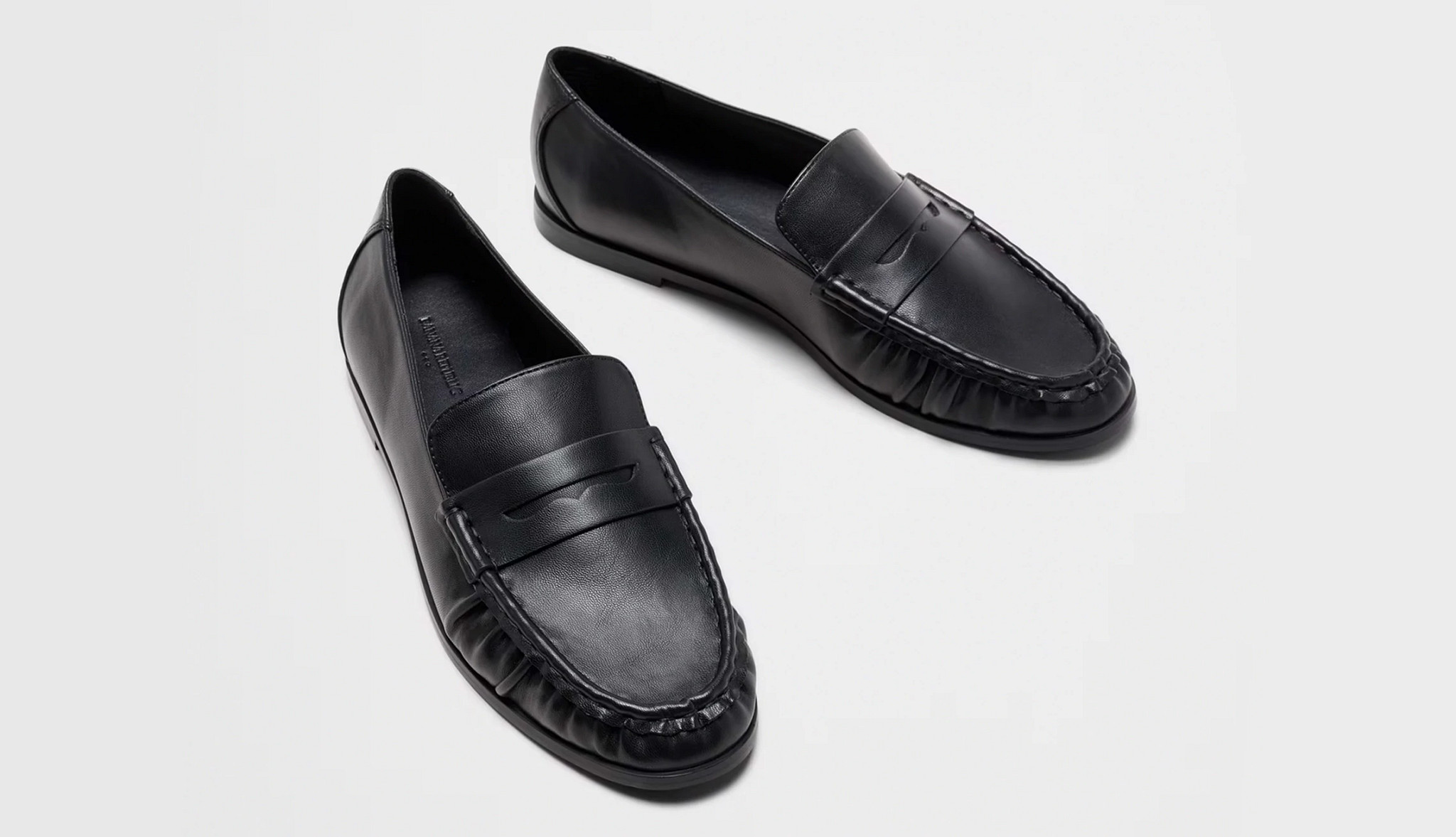 a pair of black leather slip on loafers