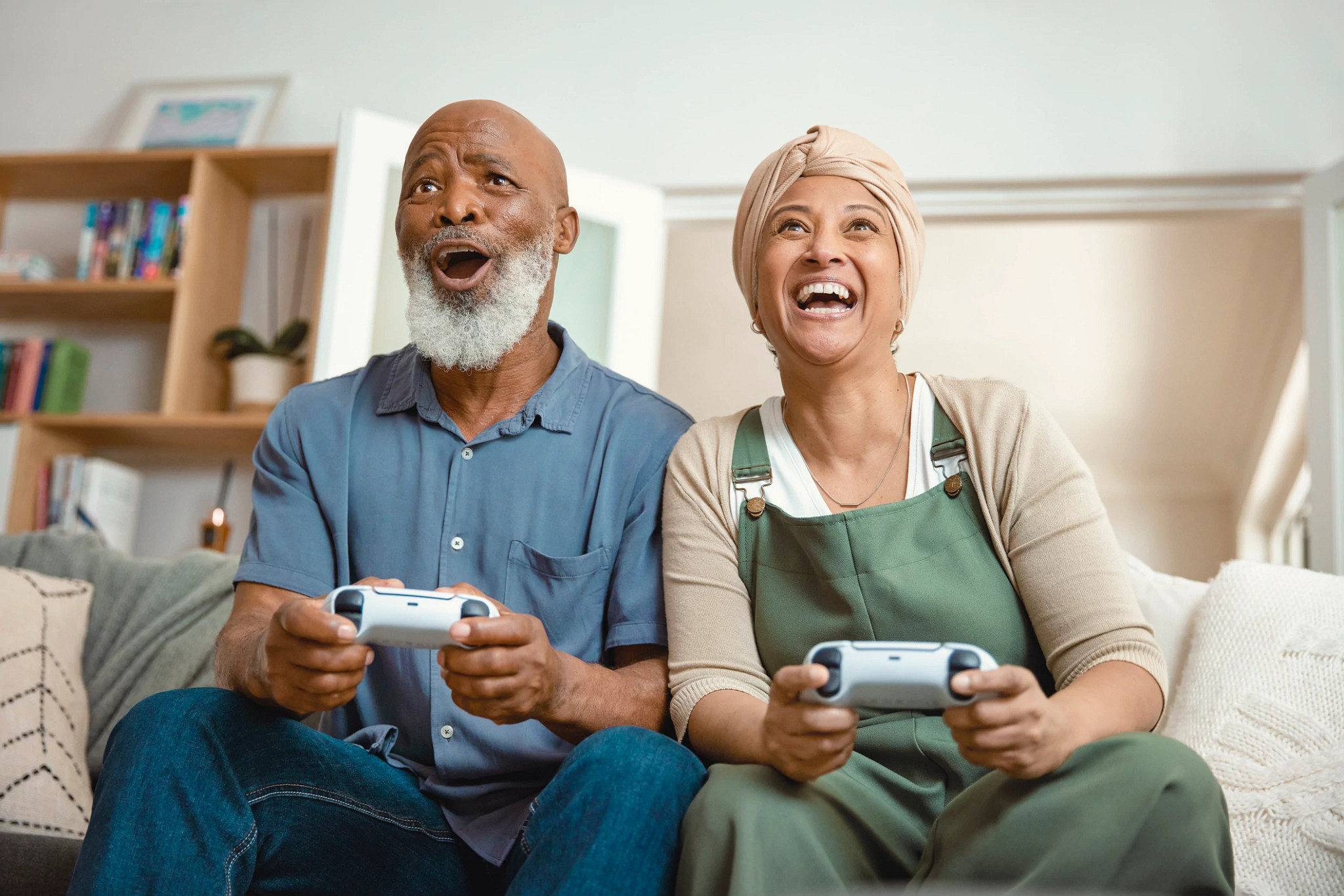 Elderly Couple's Fun Home Gaming Session: Playing Video Games on the Sofa