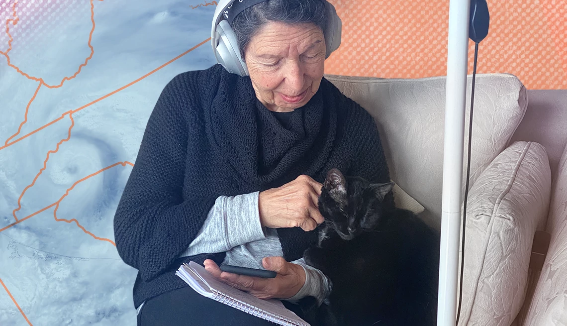 a woman wearing headphones pets a black cat
