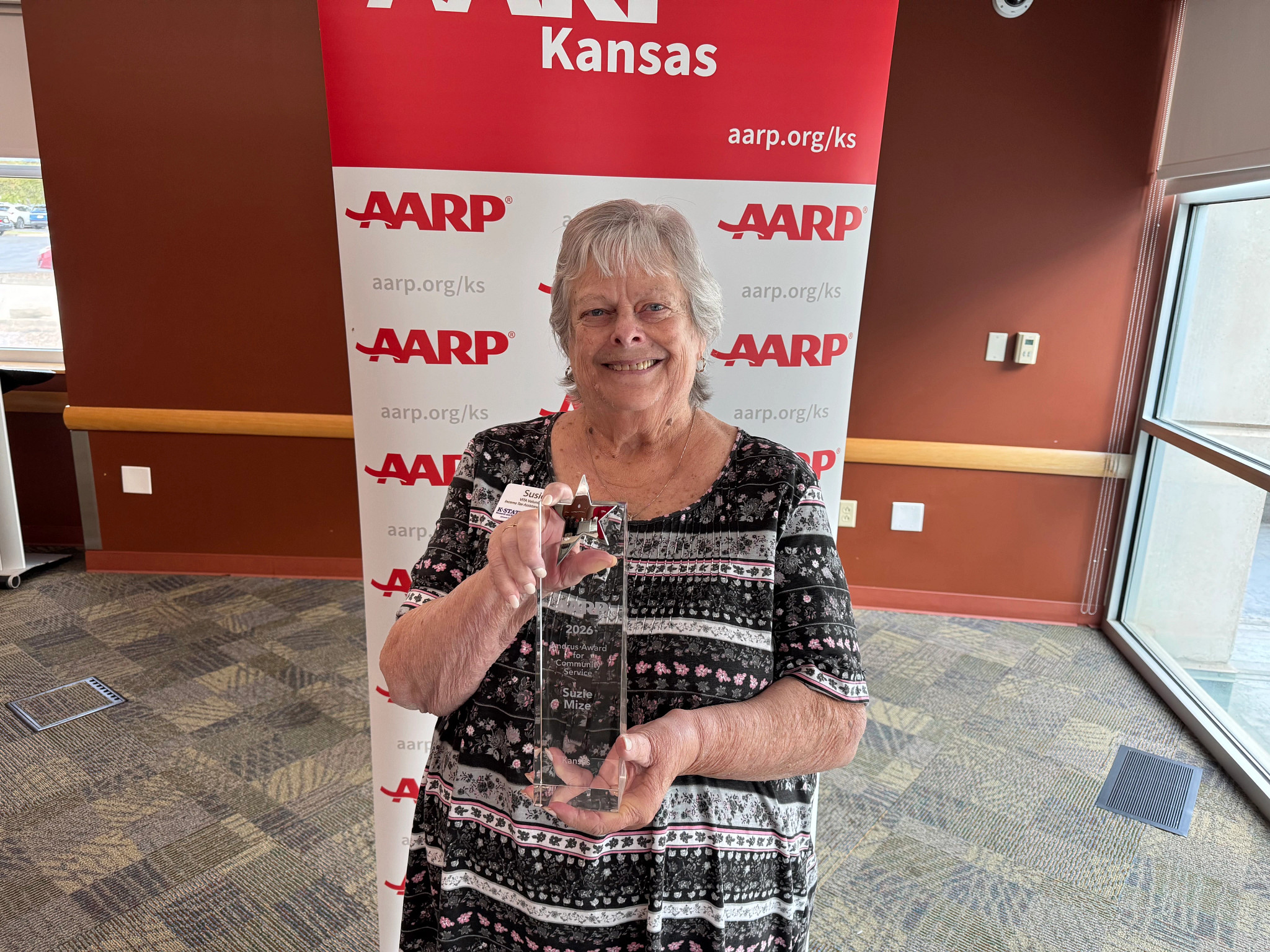 Susie Mize holding the 2026 Andrus Award for AARP Kansas