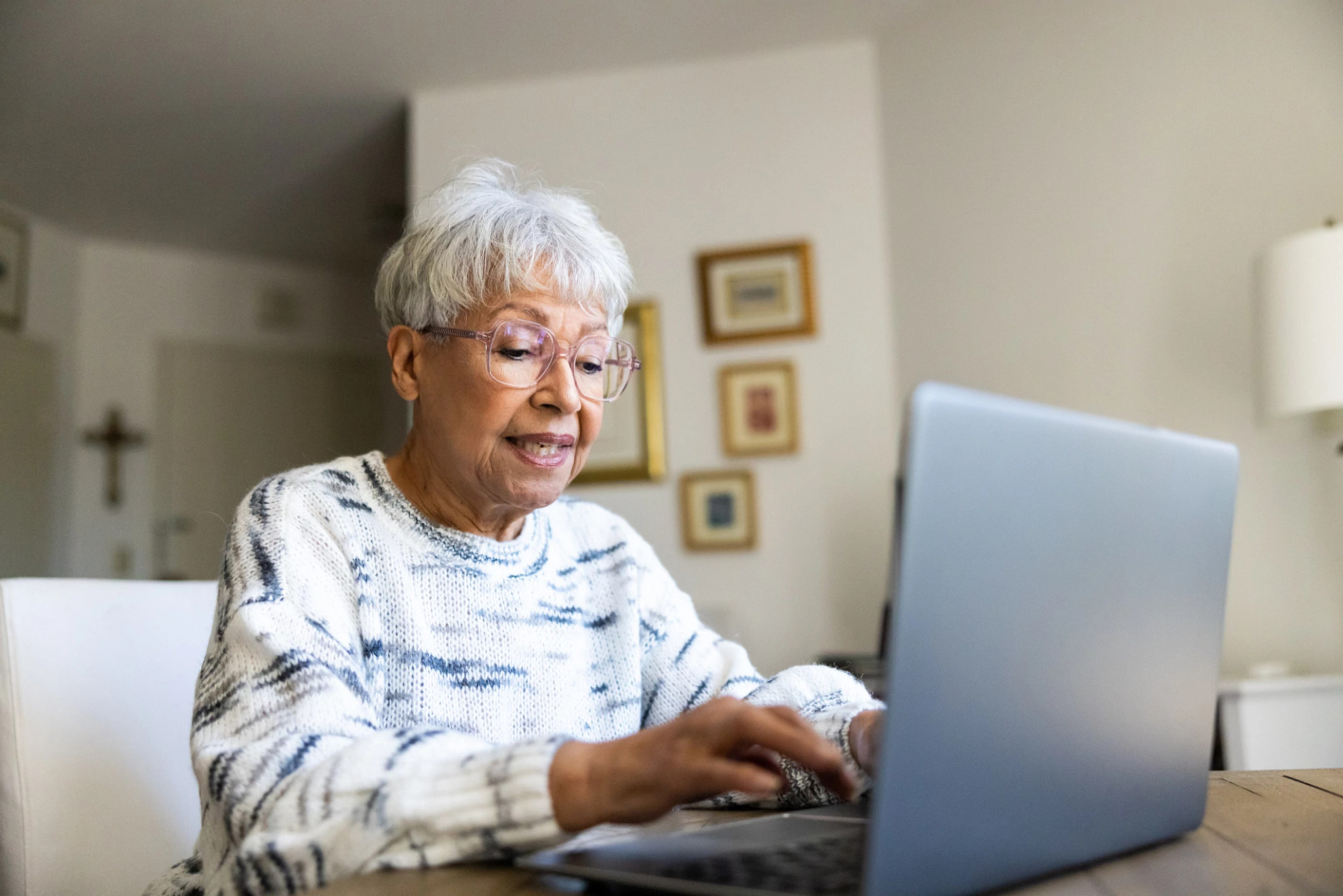A beautiful multiracial senior woman on a laptop.