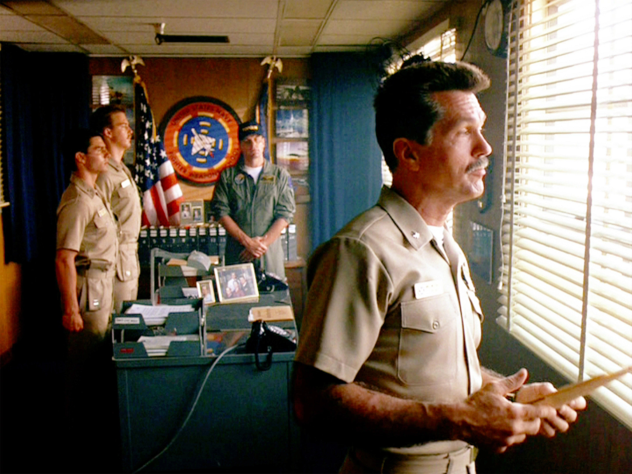 tom skerritt, tom cruise, anthony edwards and michael ironside dressed in military uniforms meeting in an office