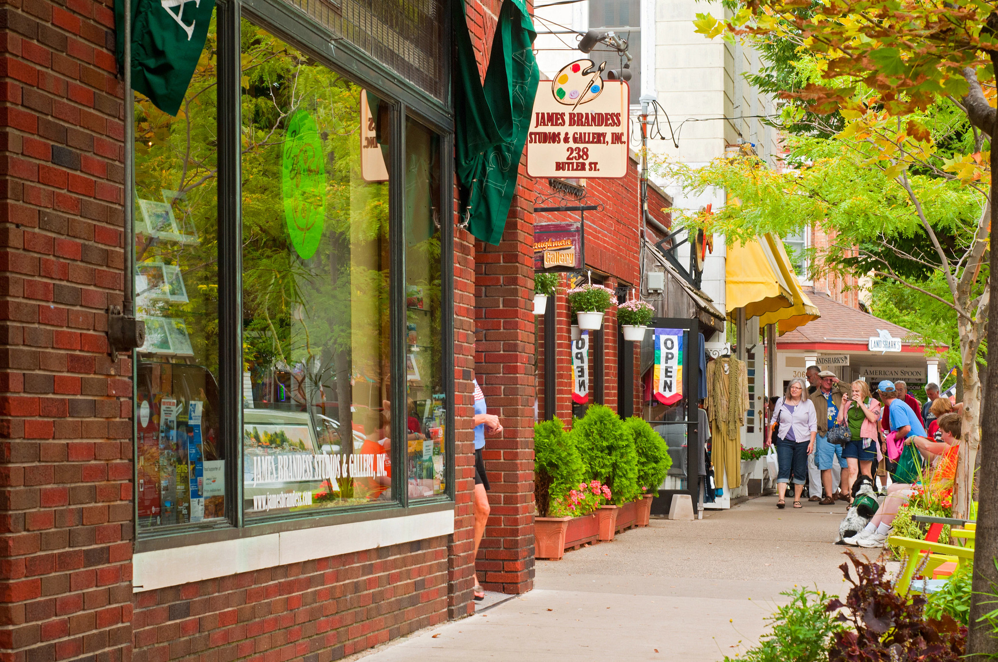 people walking on a sidewalk near storefronts