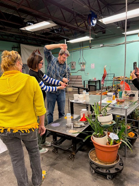 people in a glassblowing class
