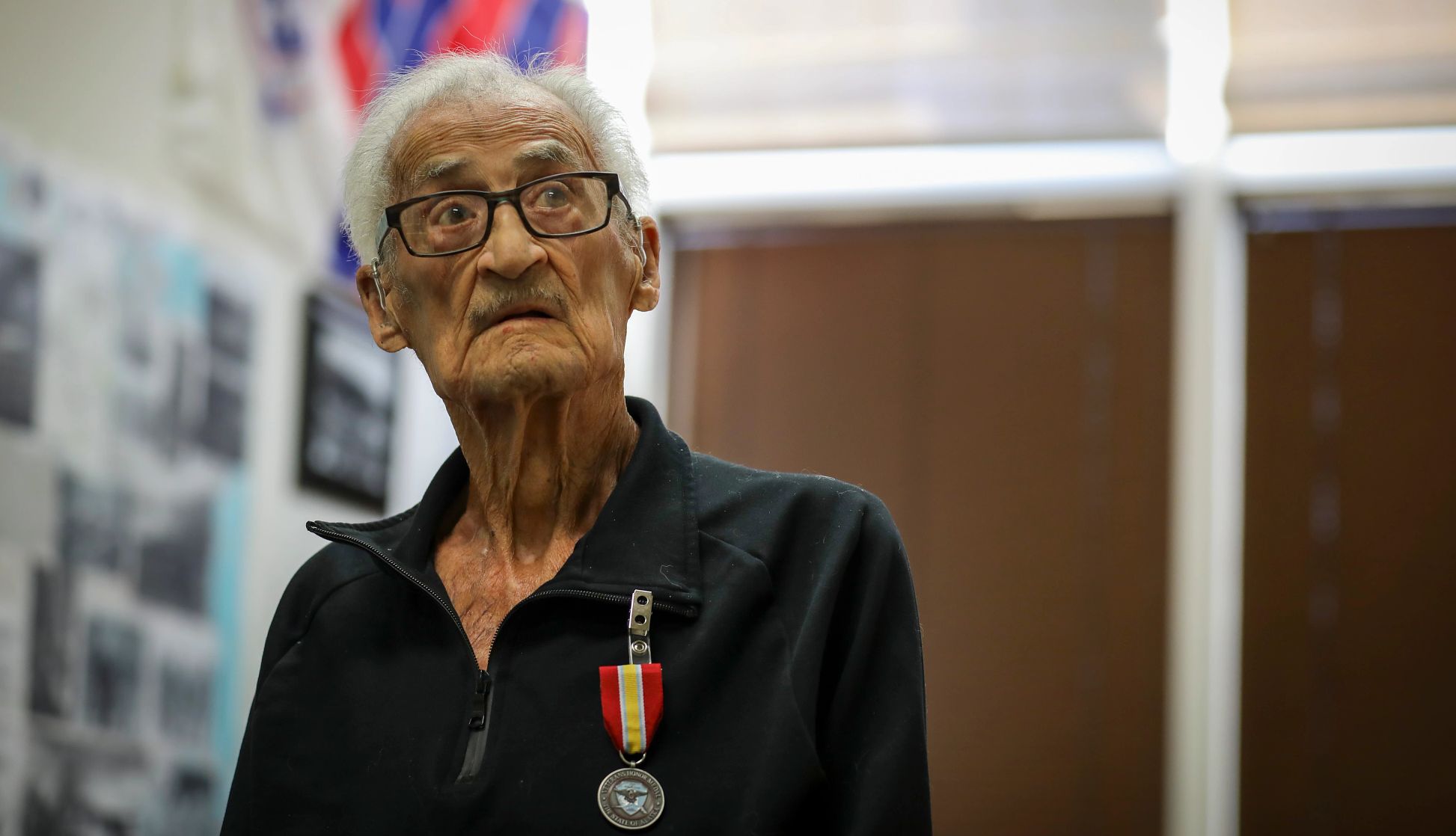 Alaska veteran receives VA health benefits Louis Gigliotti wears a polo shirt. A red and yellow striped veterans medal is pinned to the shirt collar.
