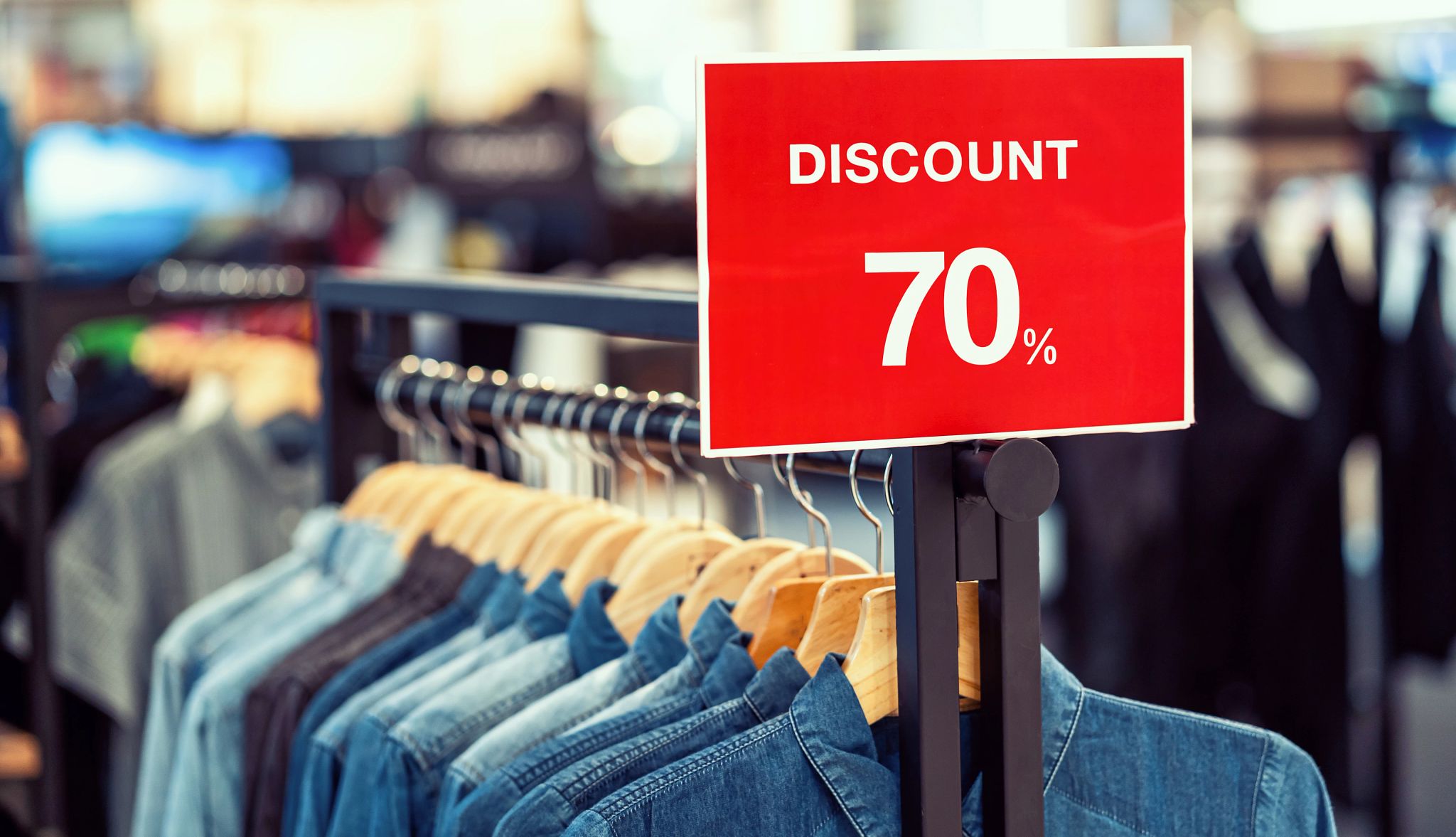 Tricks of thrifting Discount 70 percent sign over a line of jean shirts on a rack