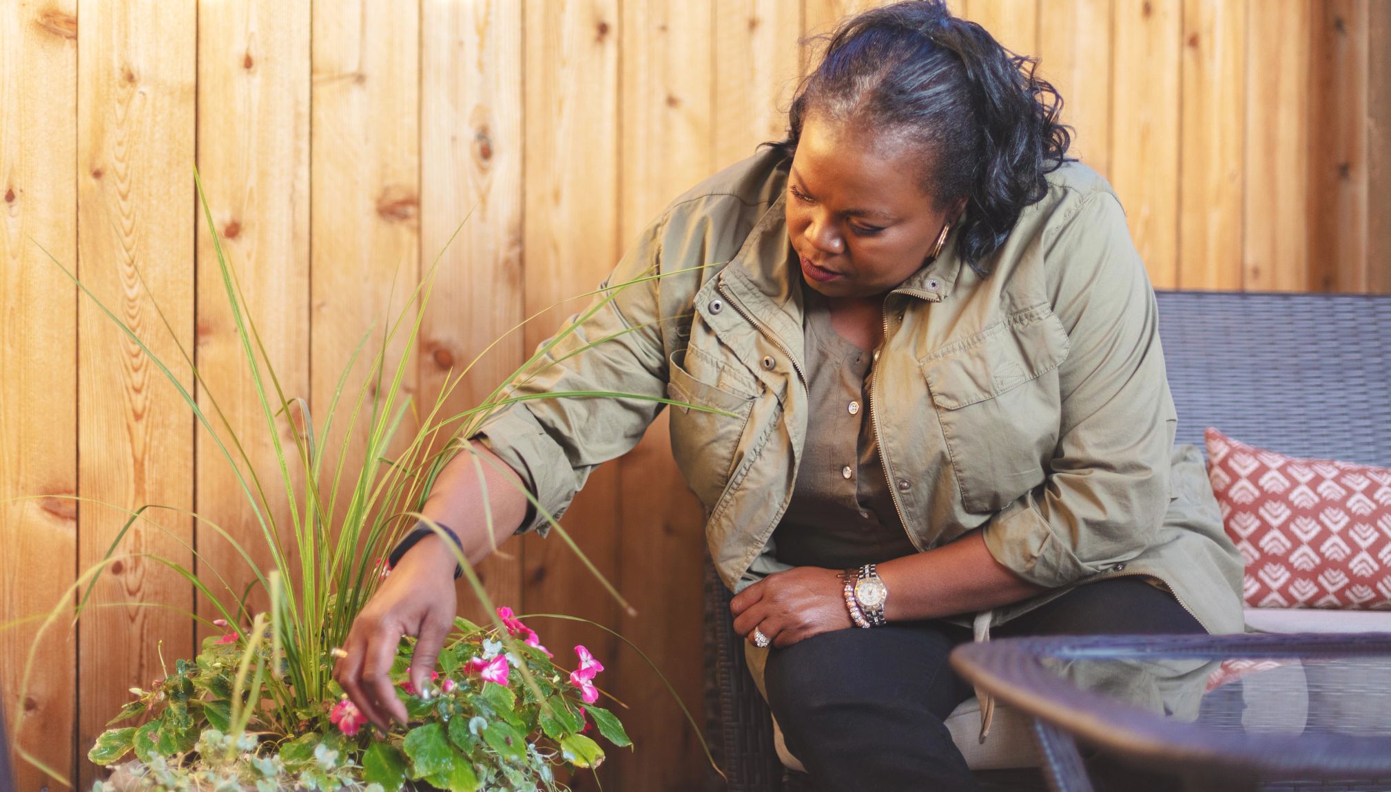 embrace simplicity woman prunes a plant on her patio