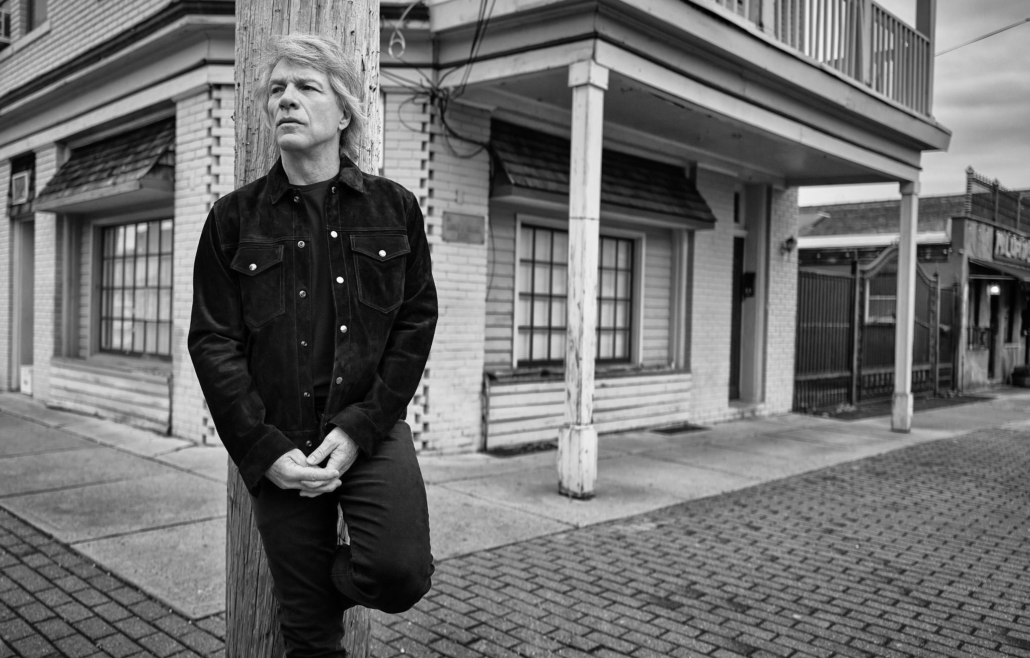 Jon Bon Jovi wooden post Jon Bon Jovi leaning on a wooden post