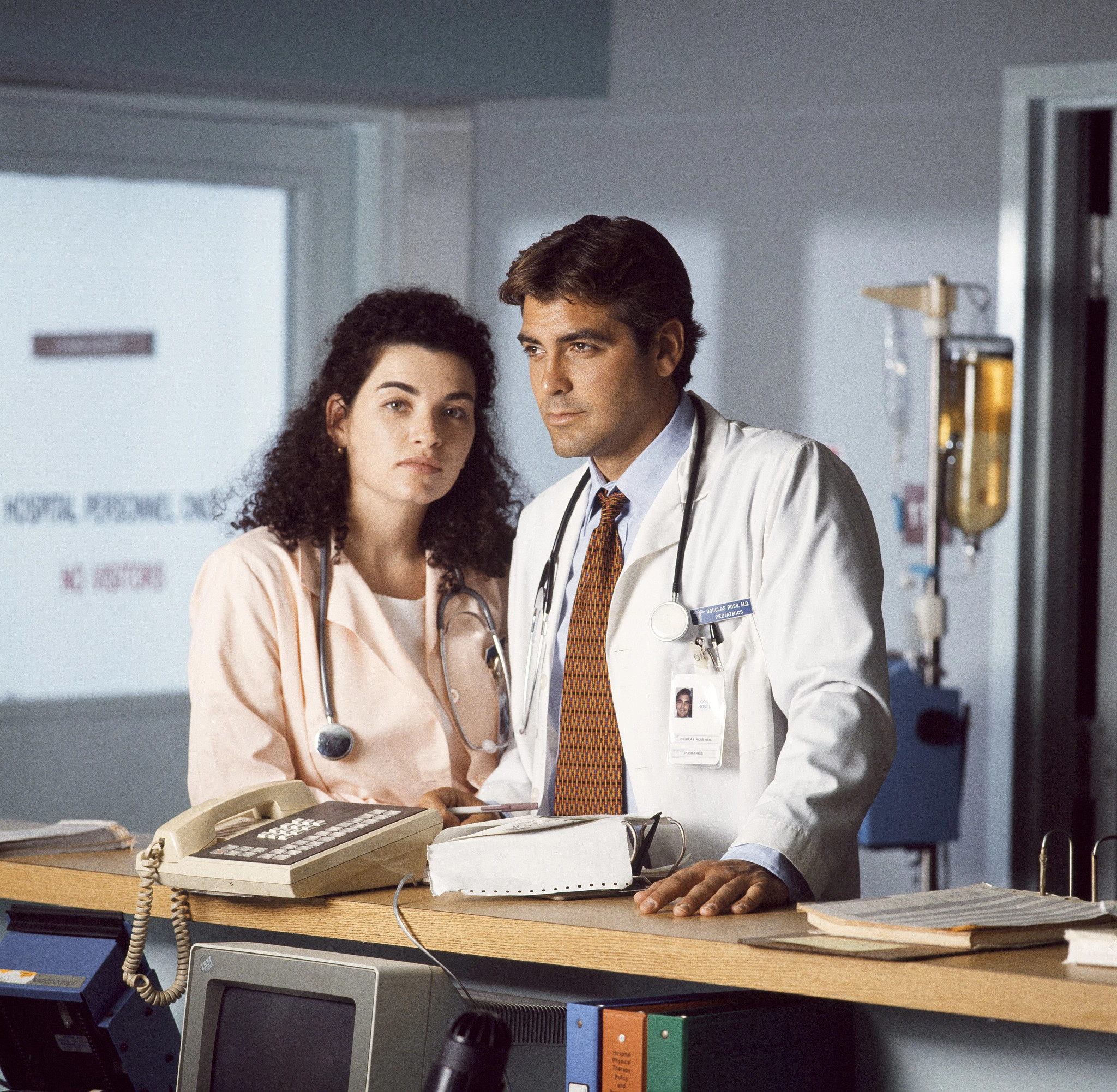Young Julianna Margulies as nurse Carol Hathaway with young George Clooney as doctor Doug Ross in a hospital in a still from E R