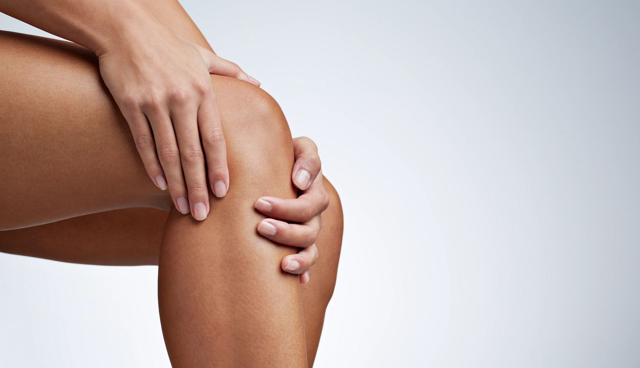Knee Pain person rubbing their knee