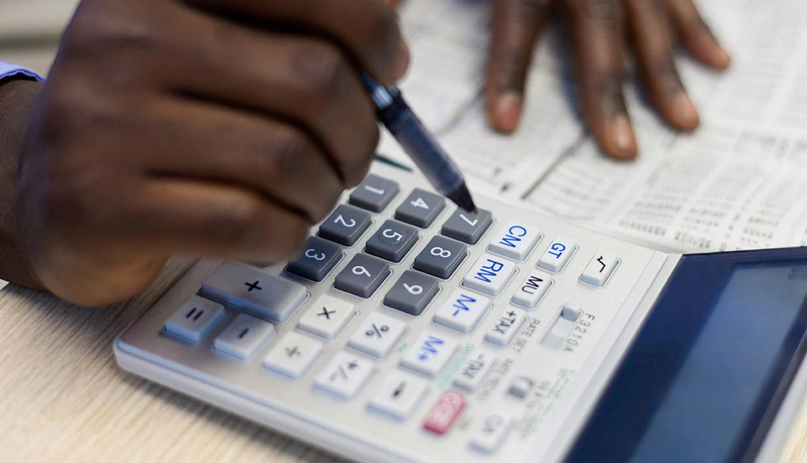 Retirement Calculator hands using calculator, retirement planning