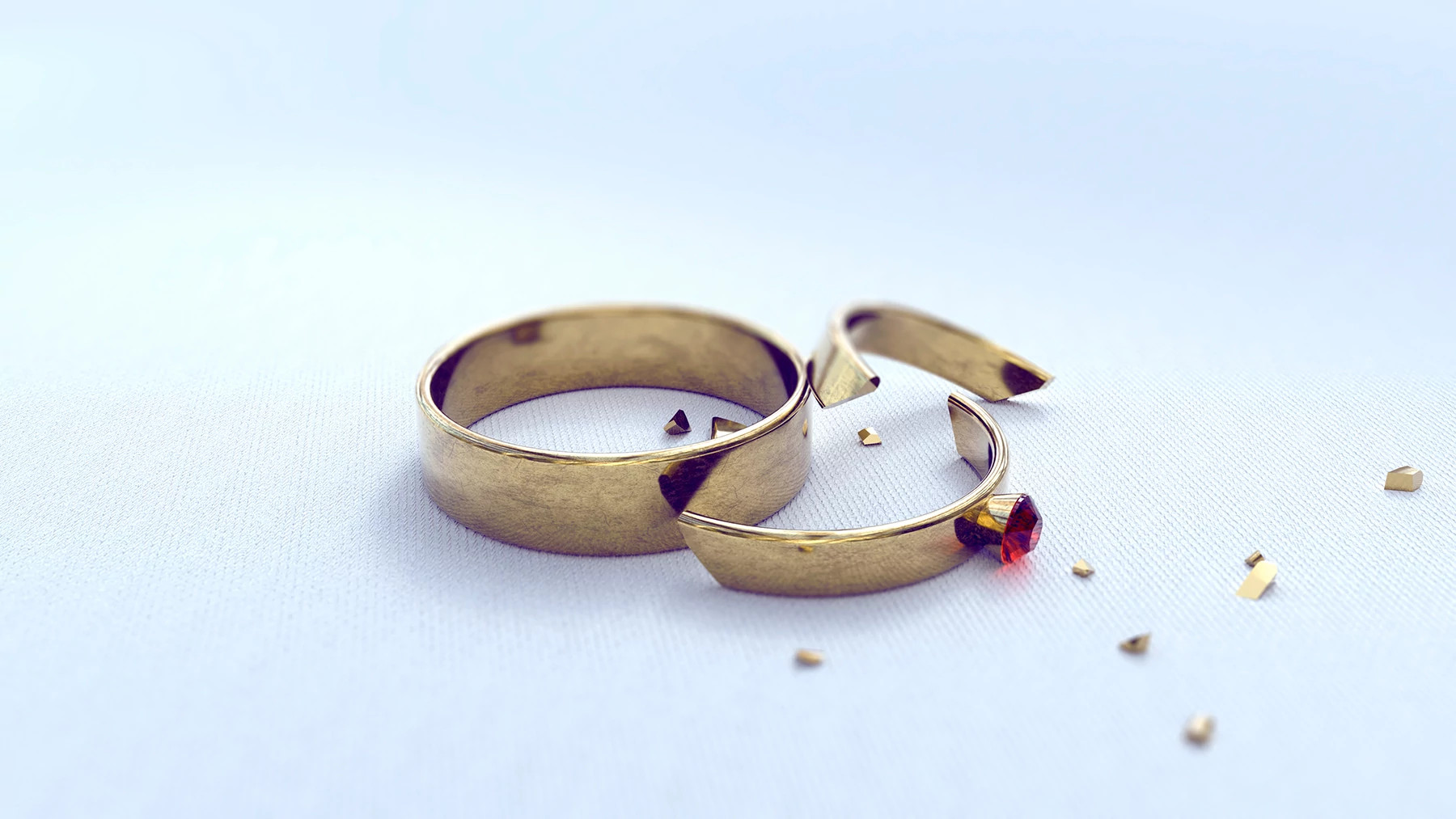wedding band and cracked engagement ring on a white background