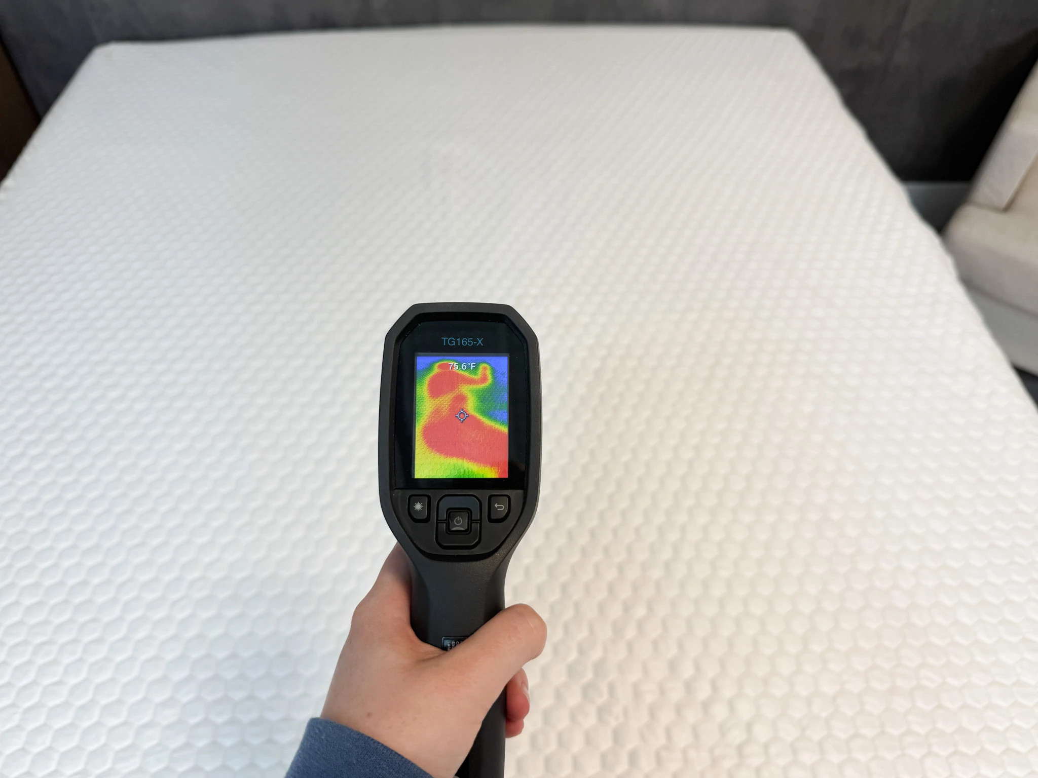 A hand holding a thermal gun pointed at the Bear GlacioTex Protector