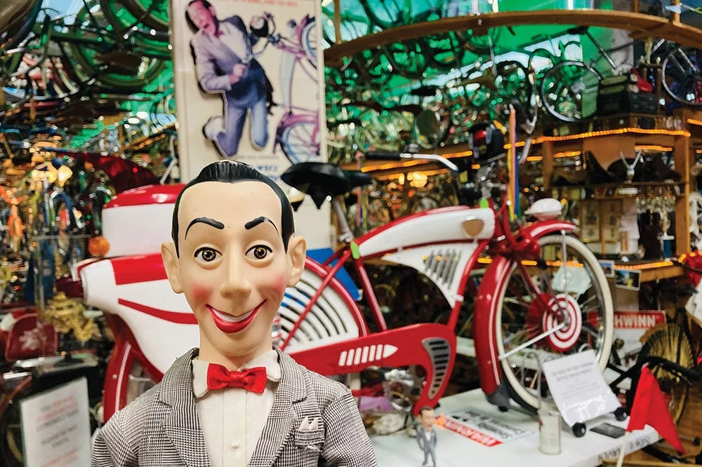 a Pee-wee Herman figurine in front of his iconic red bike