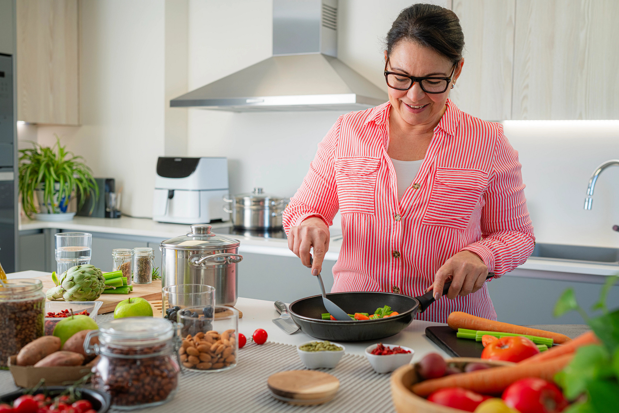 Portrait of a woman in the kitchen preparing vegetarian meal. Health diet or nutrition concept