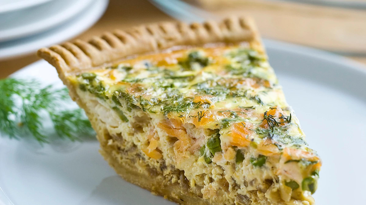 A close-up view of asparagus and smoked salmon quiche on a plate