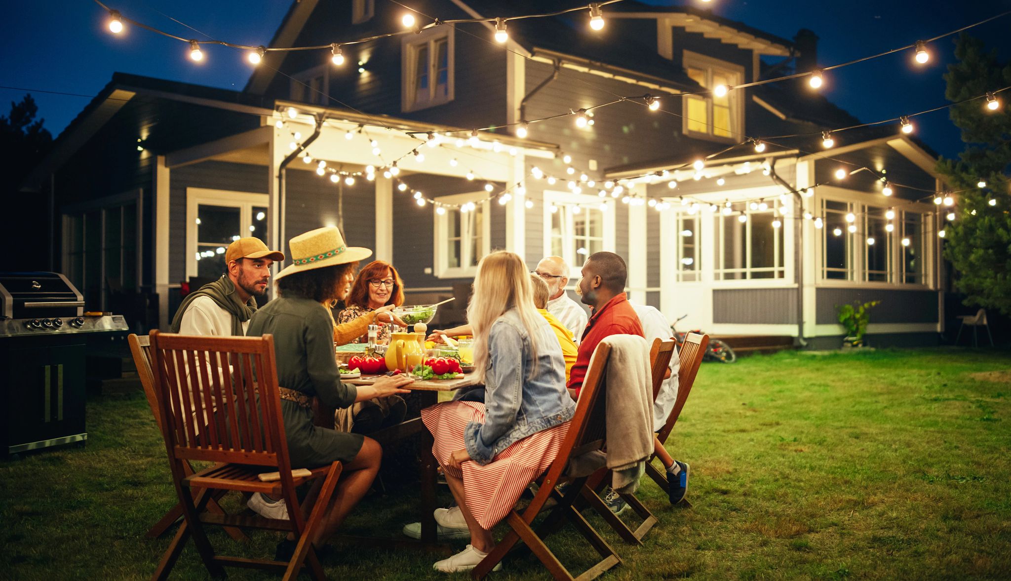 consider adding string lights outside friends and family eating dinner under lights, outside