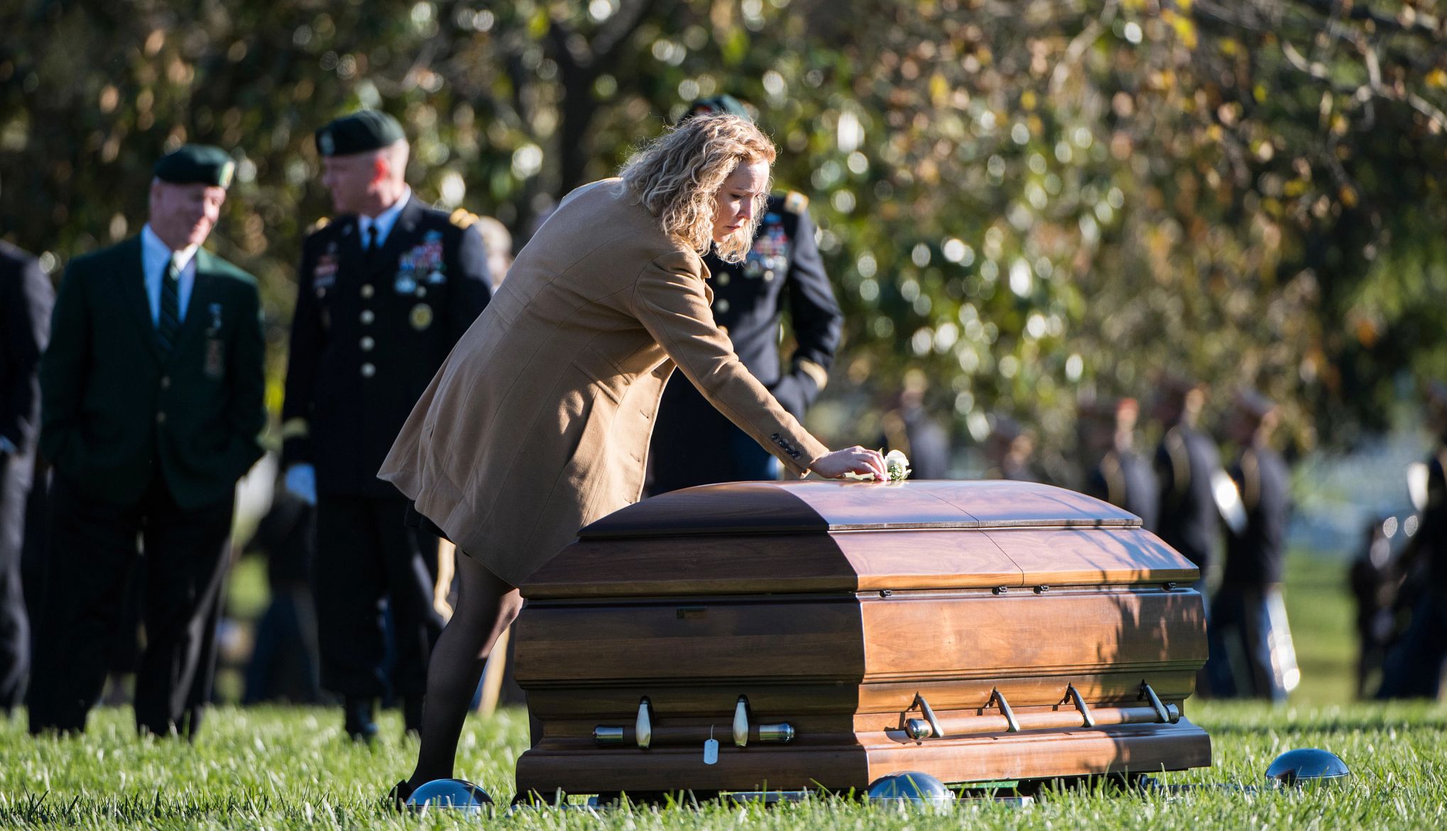 Bryan Black funeral michelle black bends down to place a rose on a closed casket