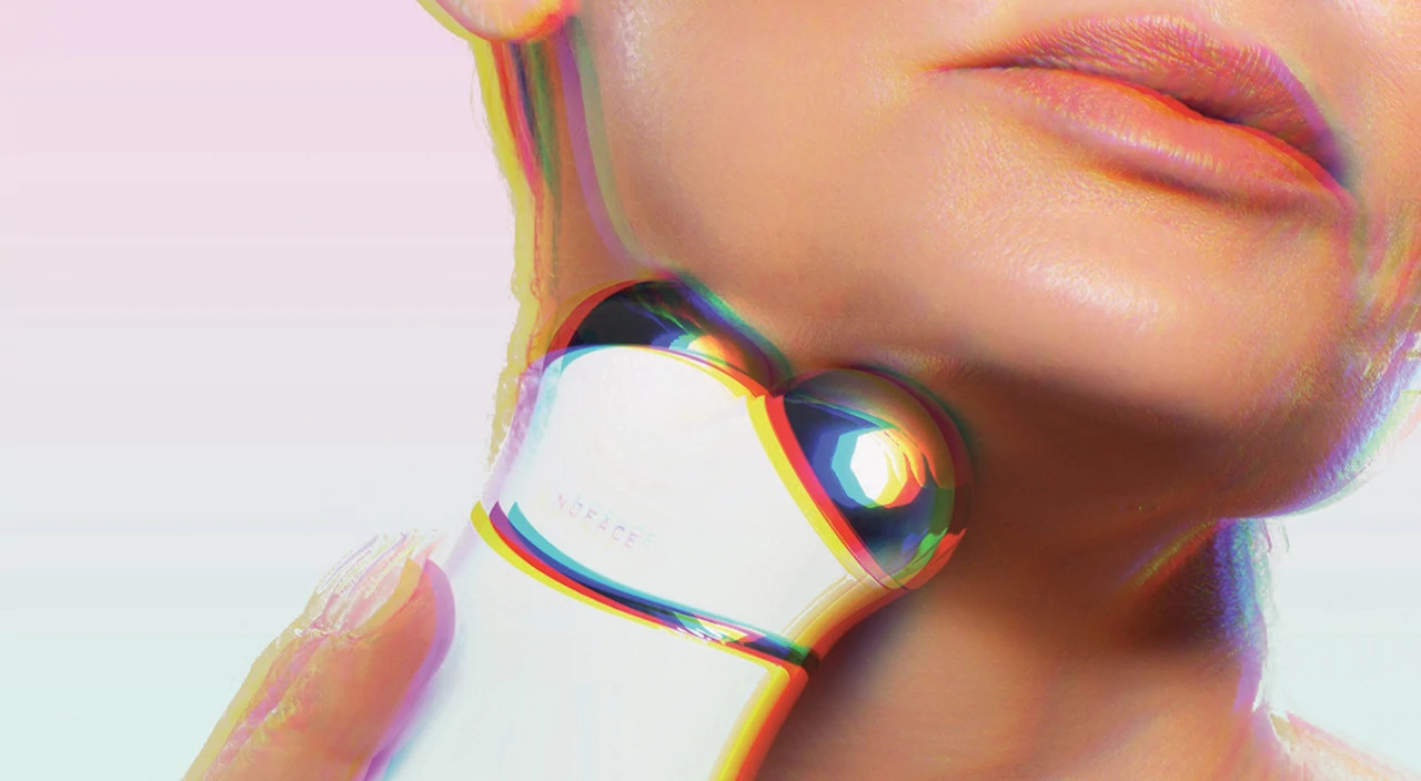 image of woman using facial toning device on jawline