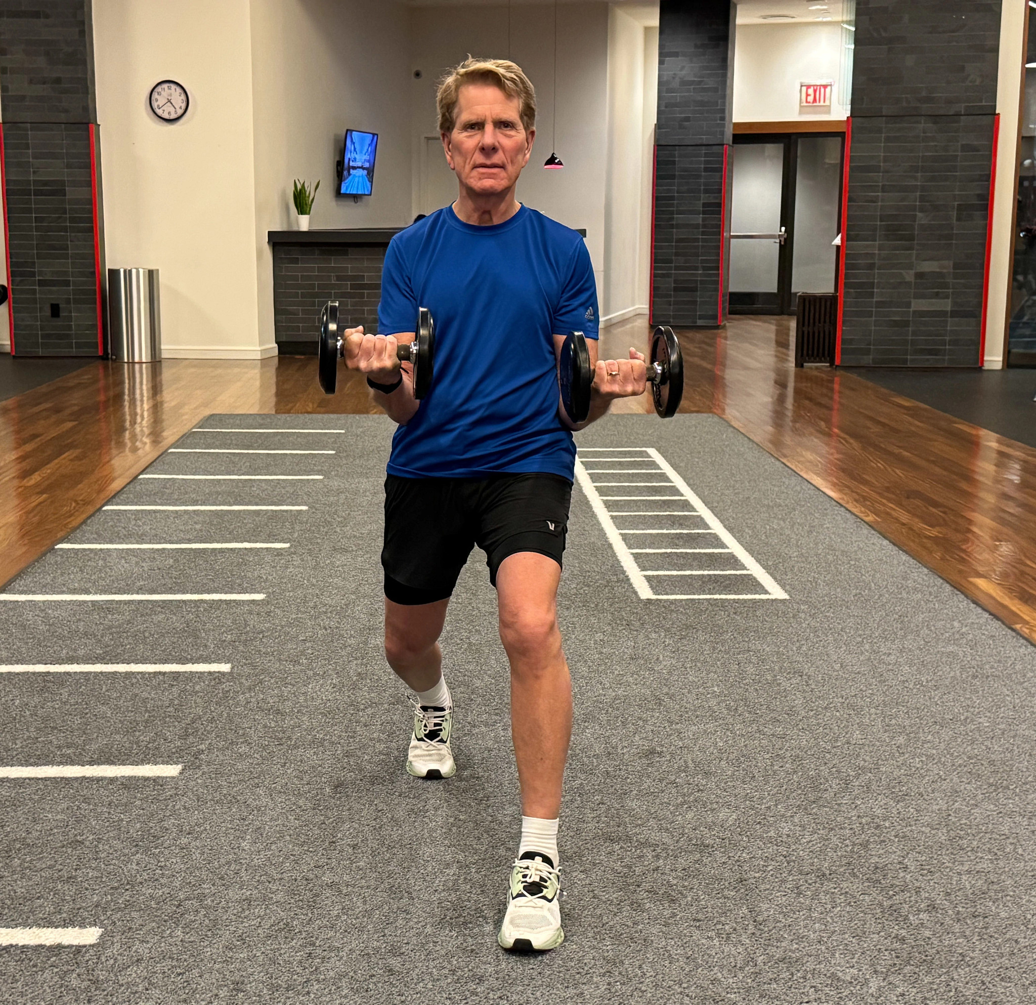 a man holding weights while doing lunges